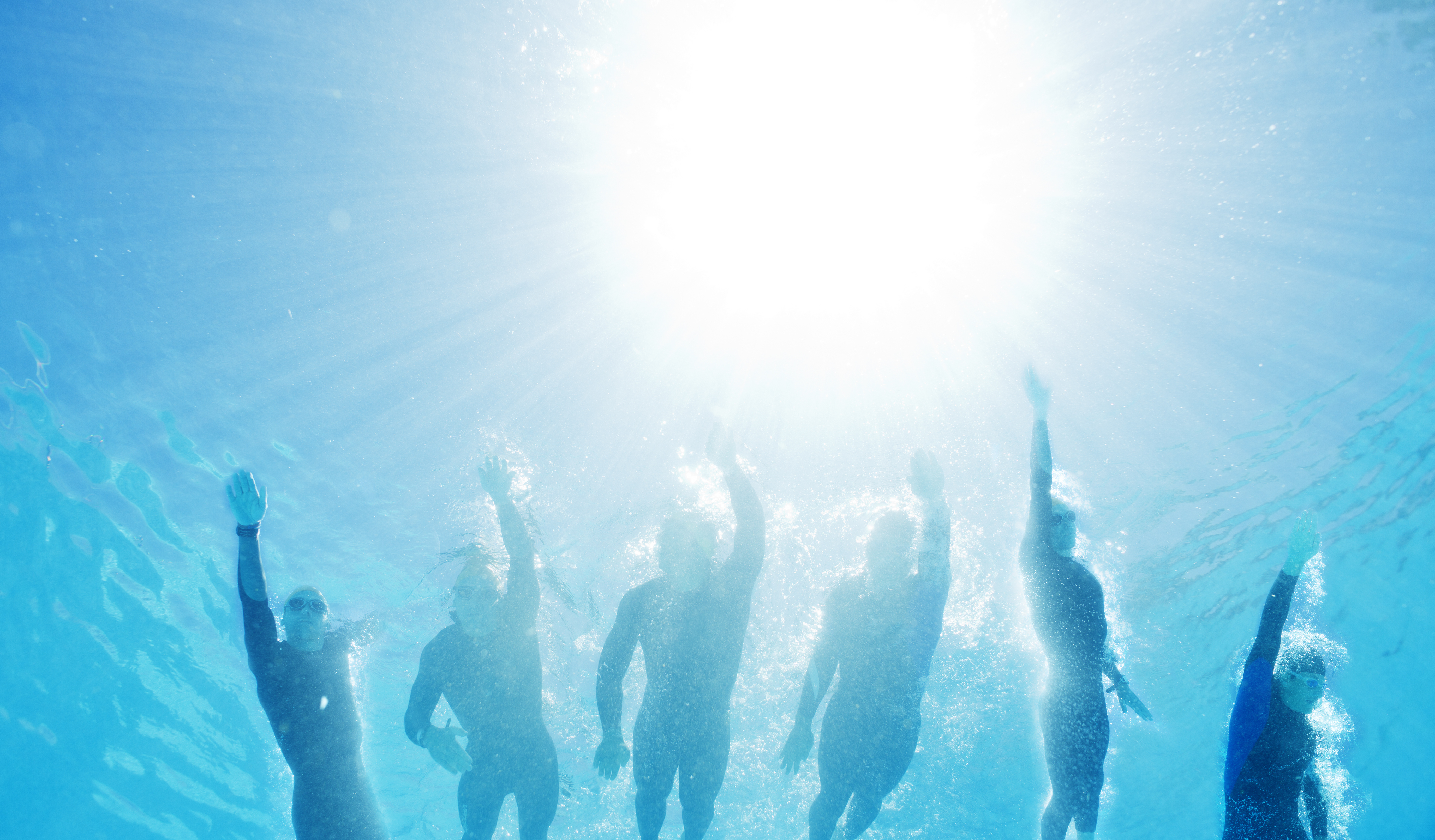 Triathletes in wetsuits underwater