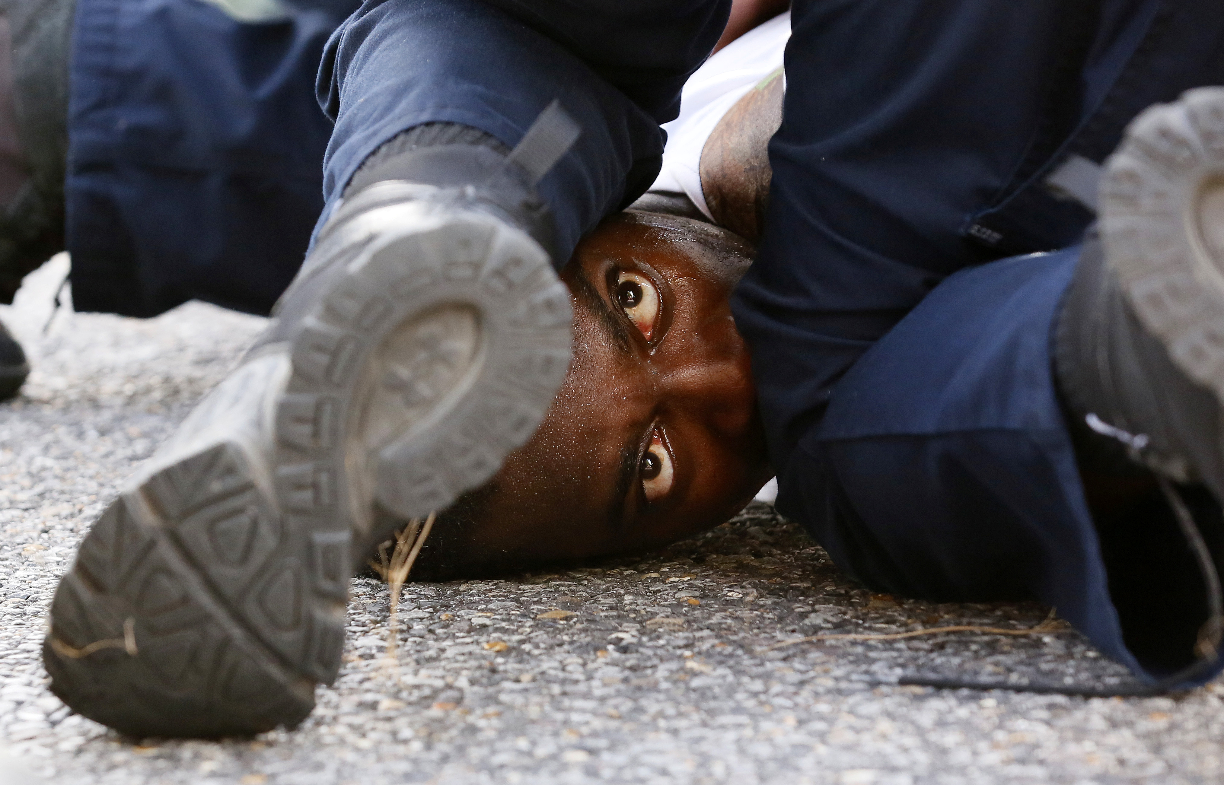 A man protesting the shooting death of Alton Sterling is detained by law enforcement near the headquarters of the Baton Rouge Police Department in Baton Rouge, Louisiana