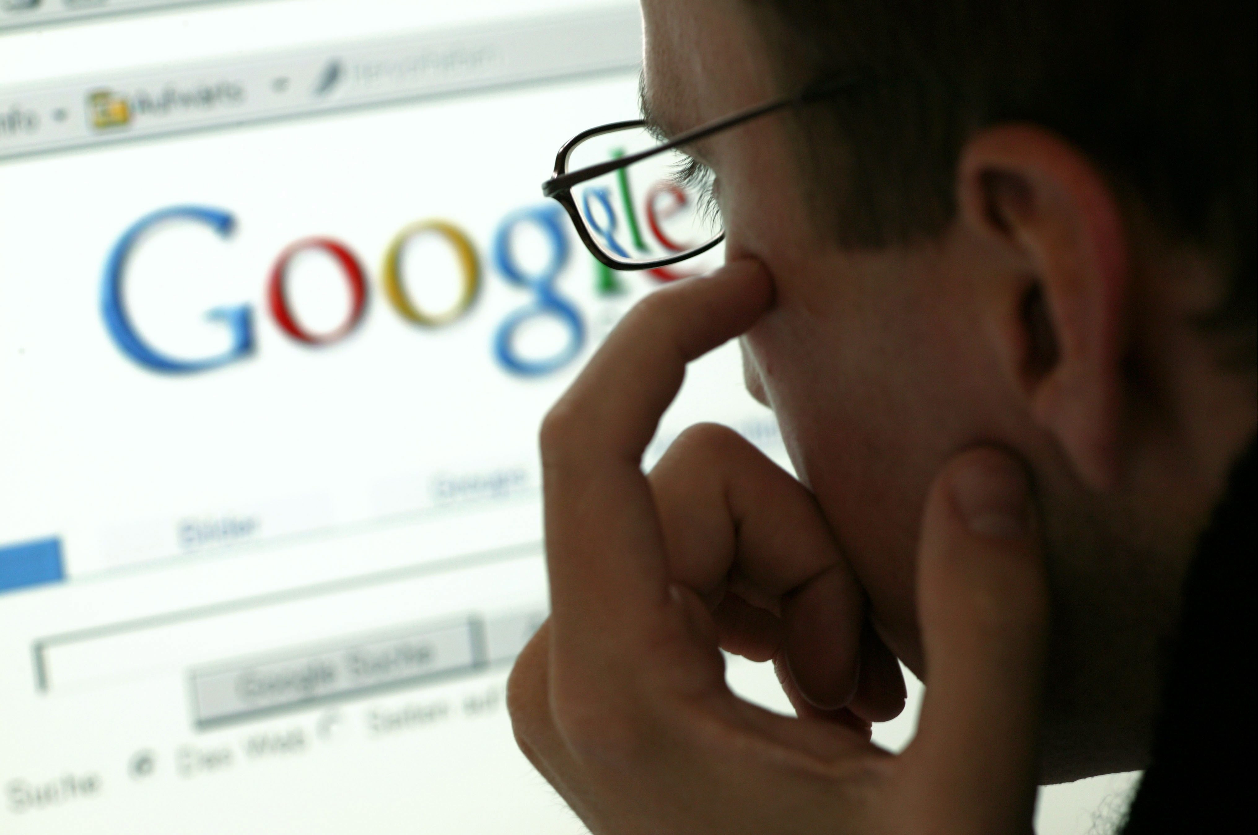 Man in front of a display with the website of the internet search engine Google.