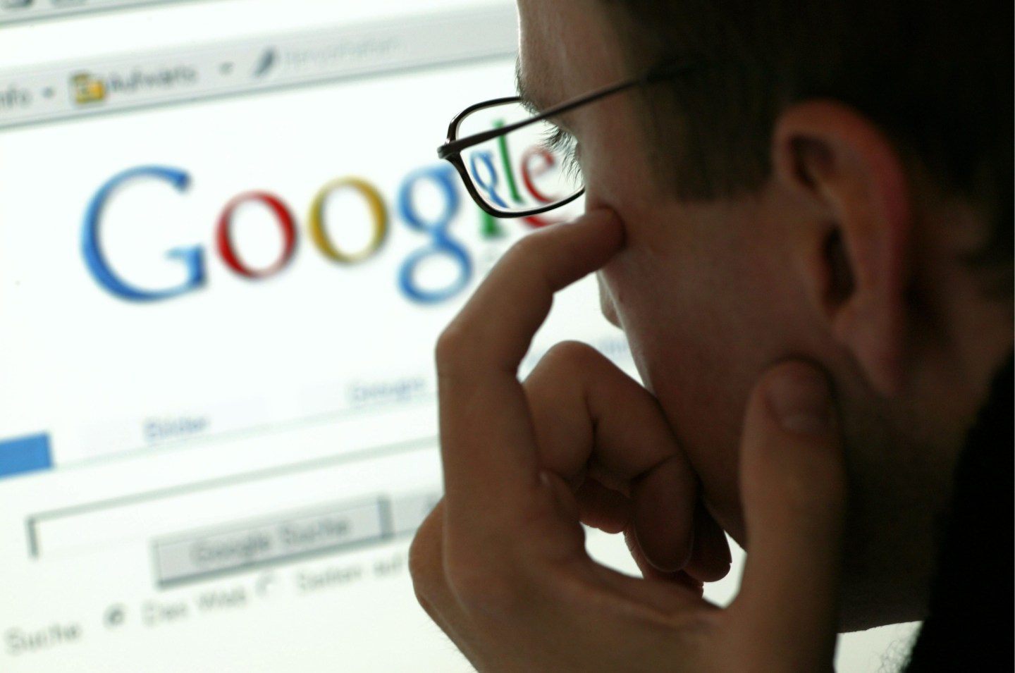 Man in front of a display with the website of the internet search engine Google.