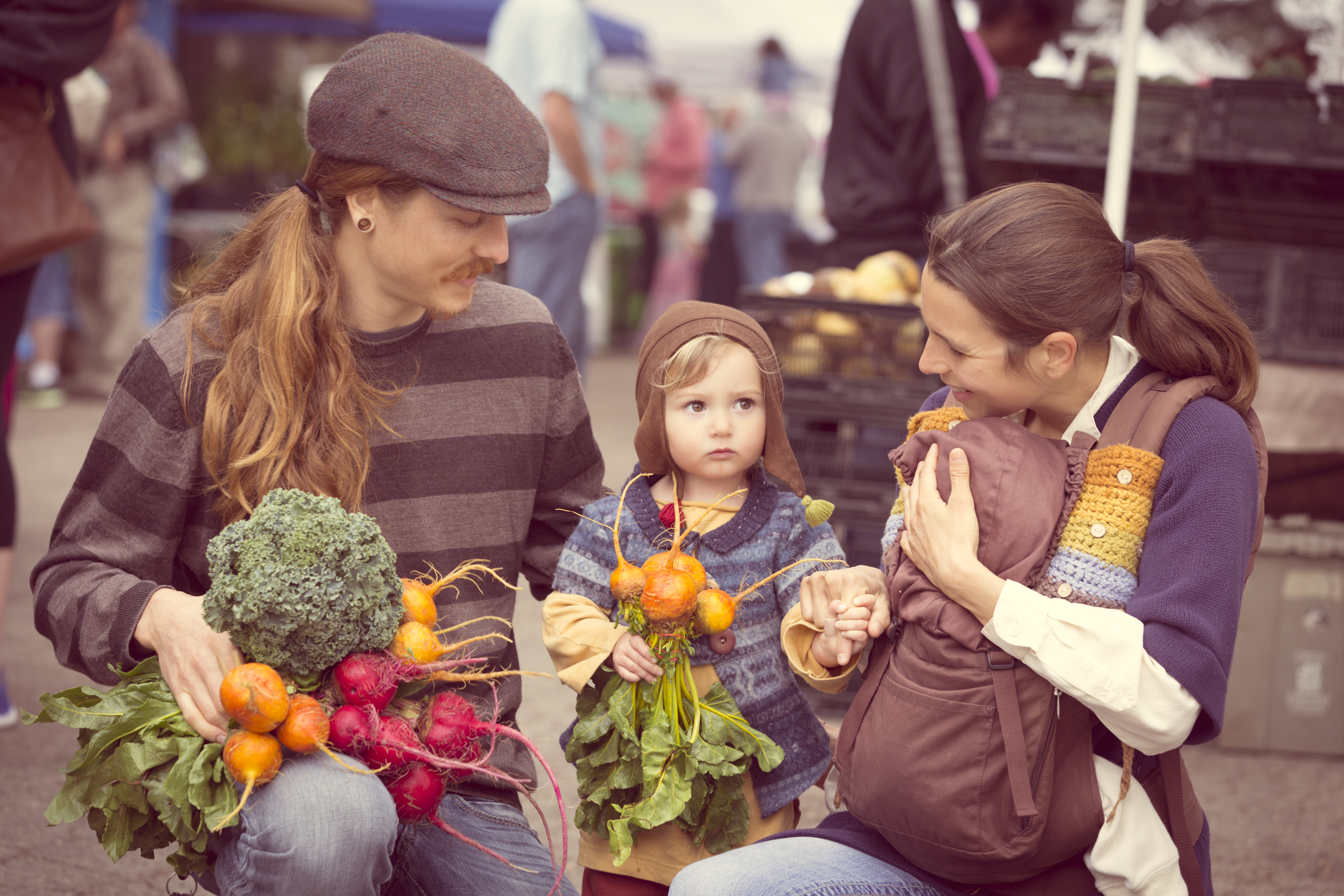 Young Hipster family with produce from outdoor farmers market