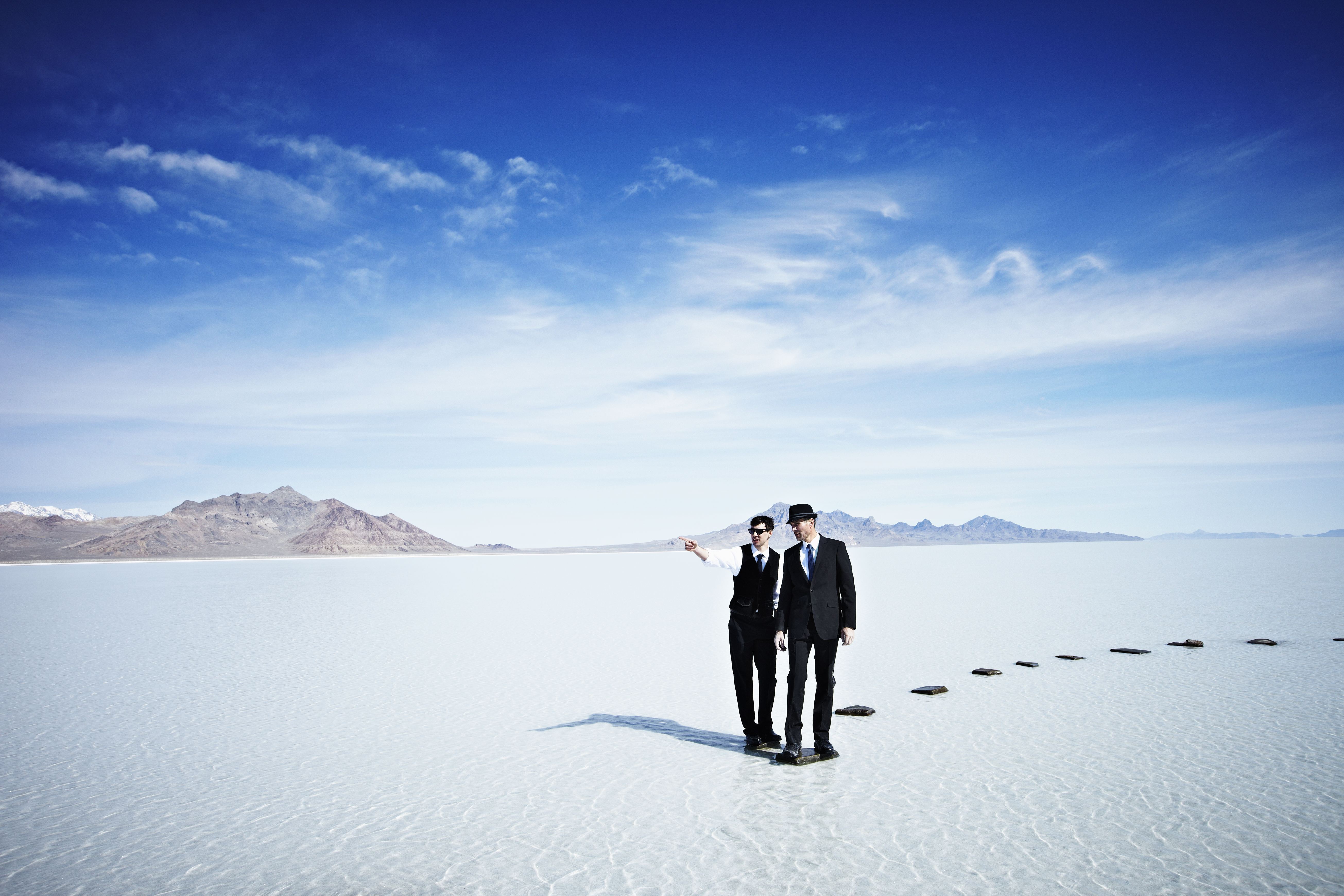 Businessmen standing at end of pathway in lake