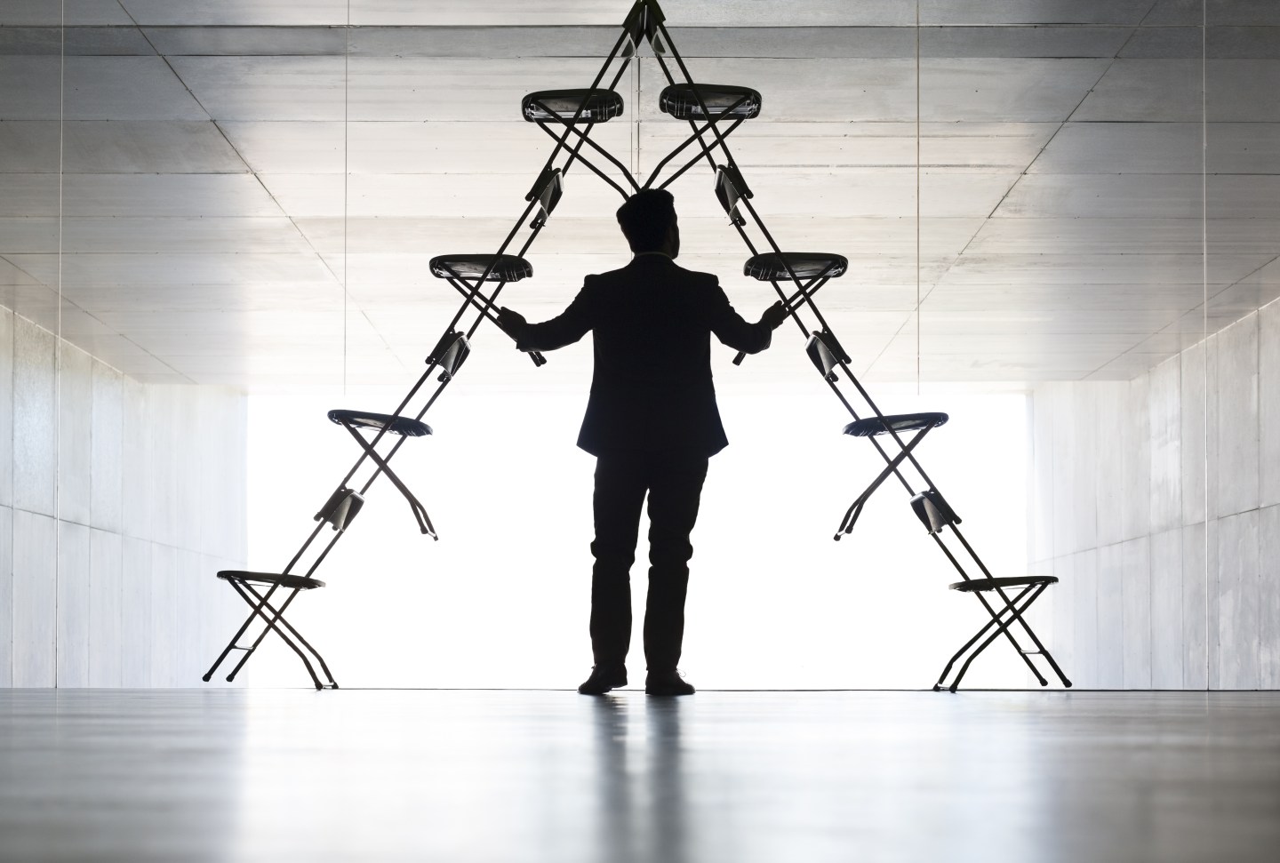 Businessman arranging office chair installation art