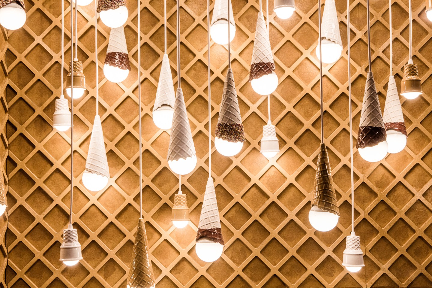 Dangling light fixtures created by artist Alex Garnett in a room dedicated to ice cream cones during a press preview of the Museum of Ice Cream in New York.