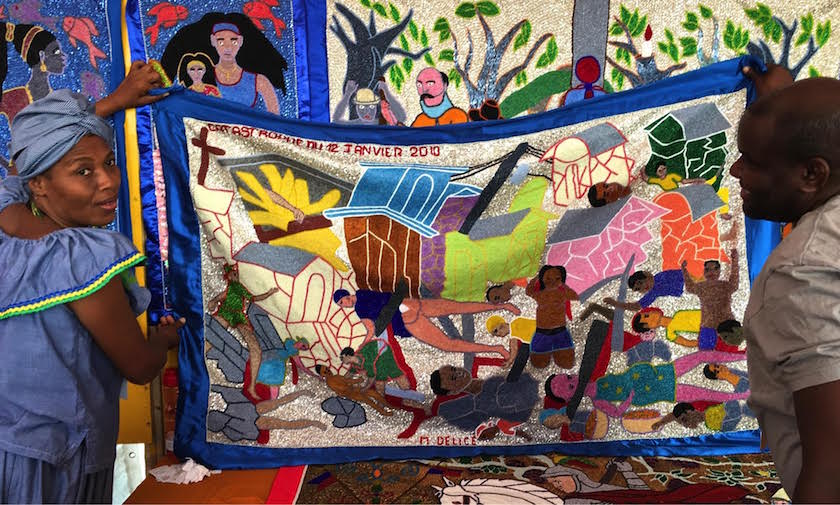 Haitian flag makers unfurling a piece at the International Folk Art Market in Santa Fe, New Mexico