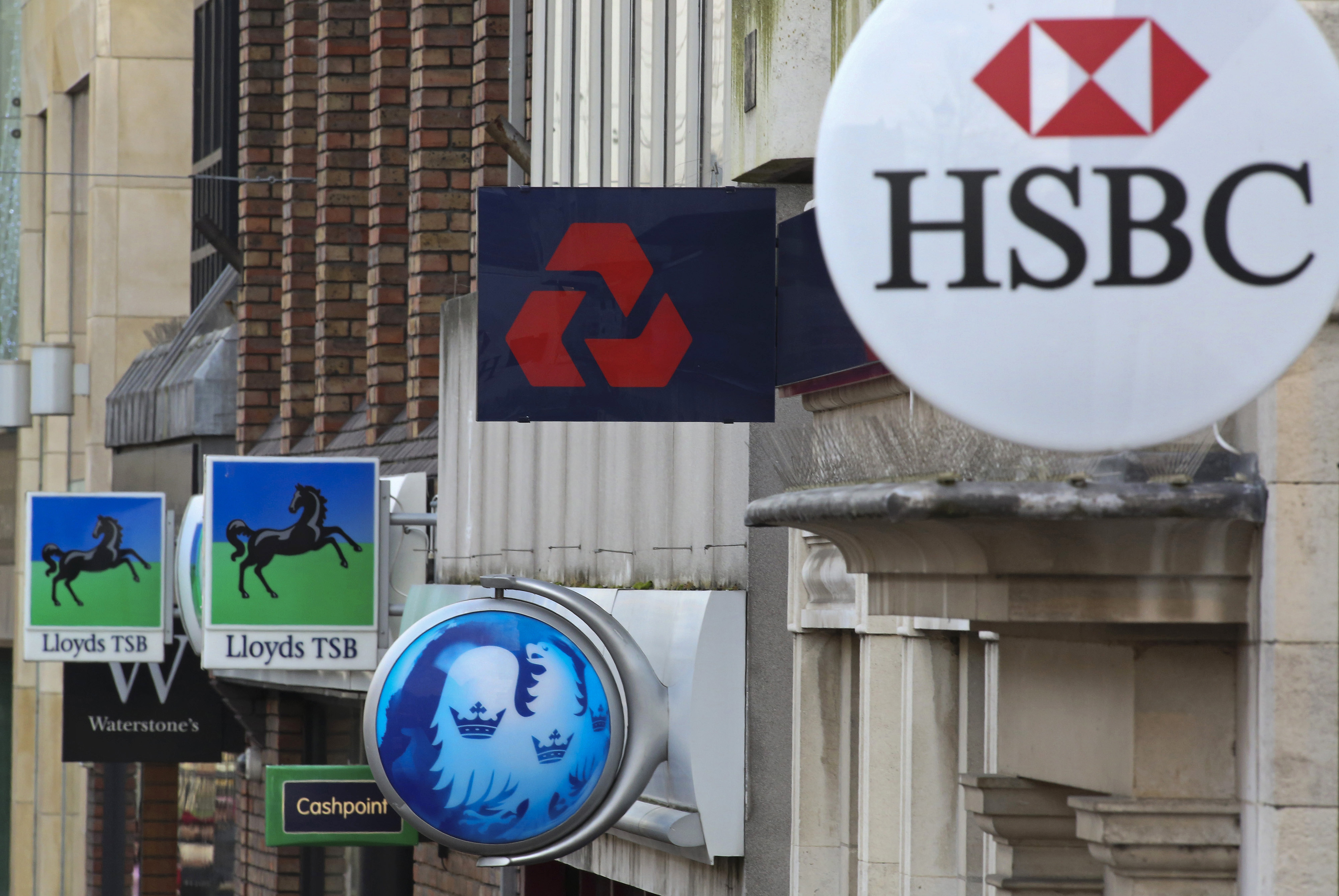 Signs sit outside branches of banks in the UK.