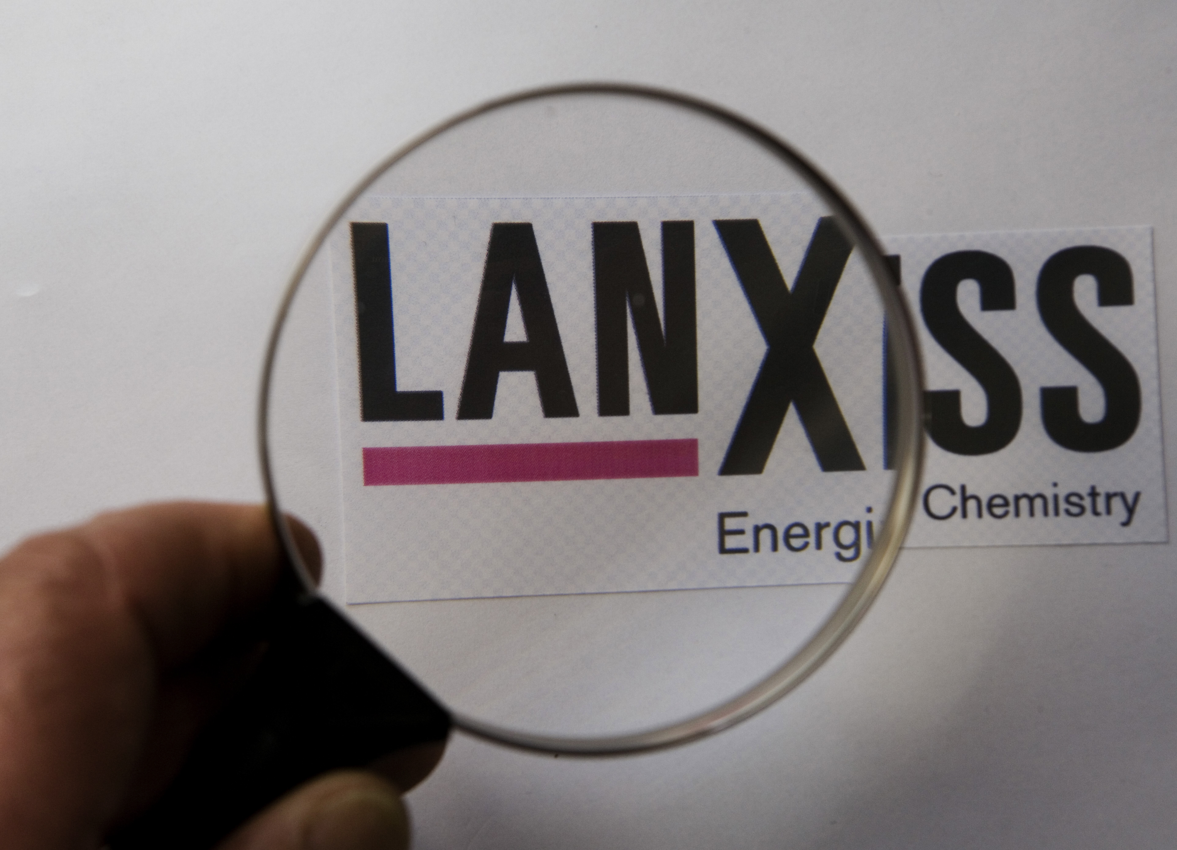 Magnifying glass with logo Lanxess AG.