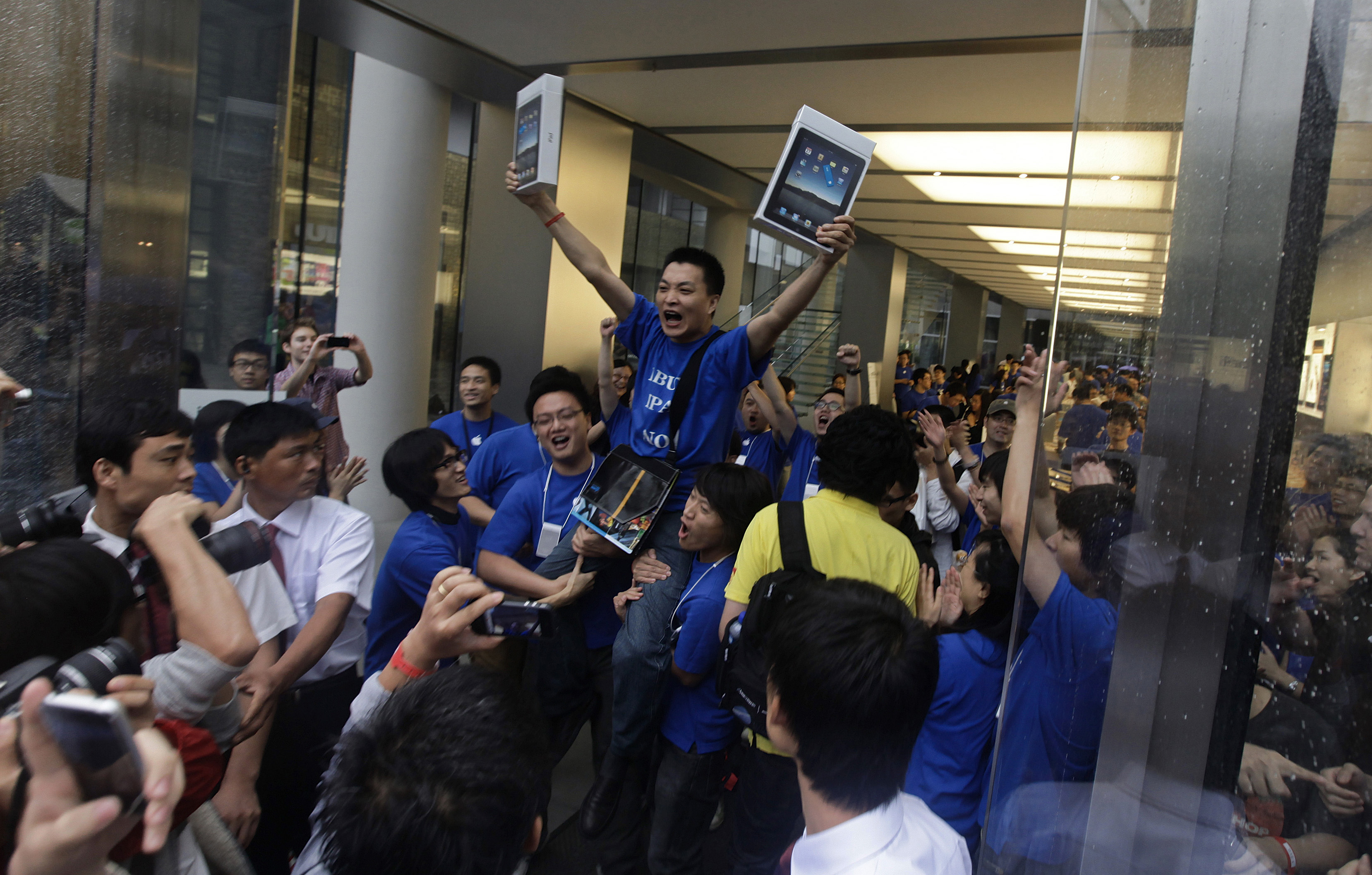 Customer Han Ziwen holds up his iPads at an Apple flagship store in Beijing