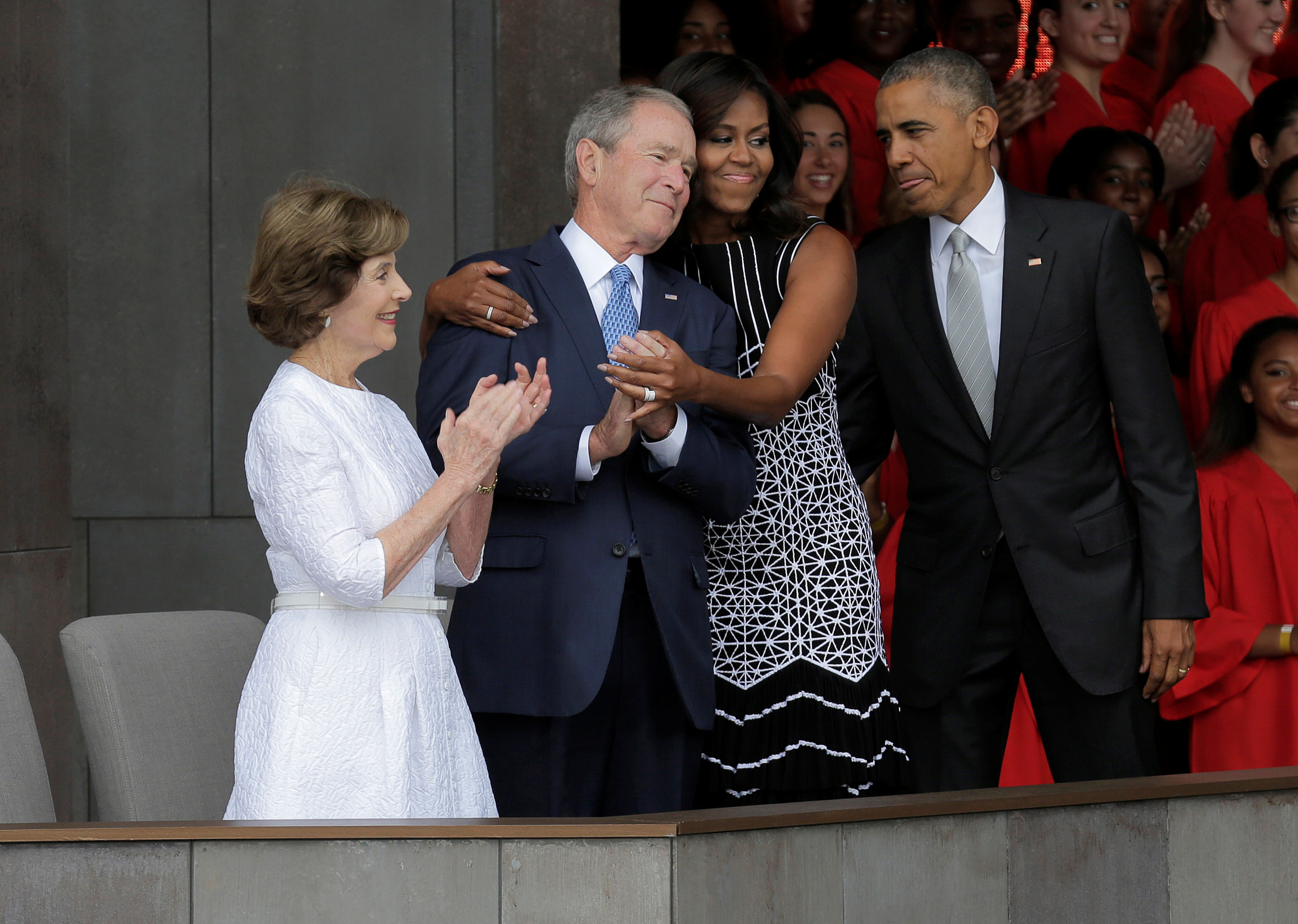 U.S. First Lady Michelle Obama hugs former U.S. President George W. Bush as she arrives for the dedication of the Smithsonians National Museum of African American History and Culture in Washington