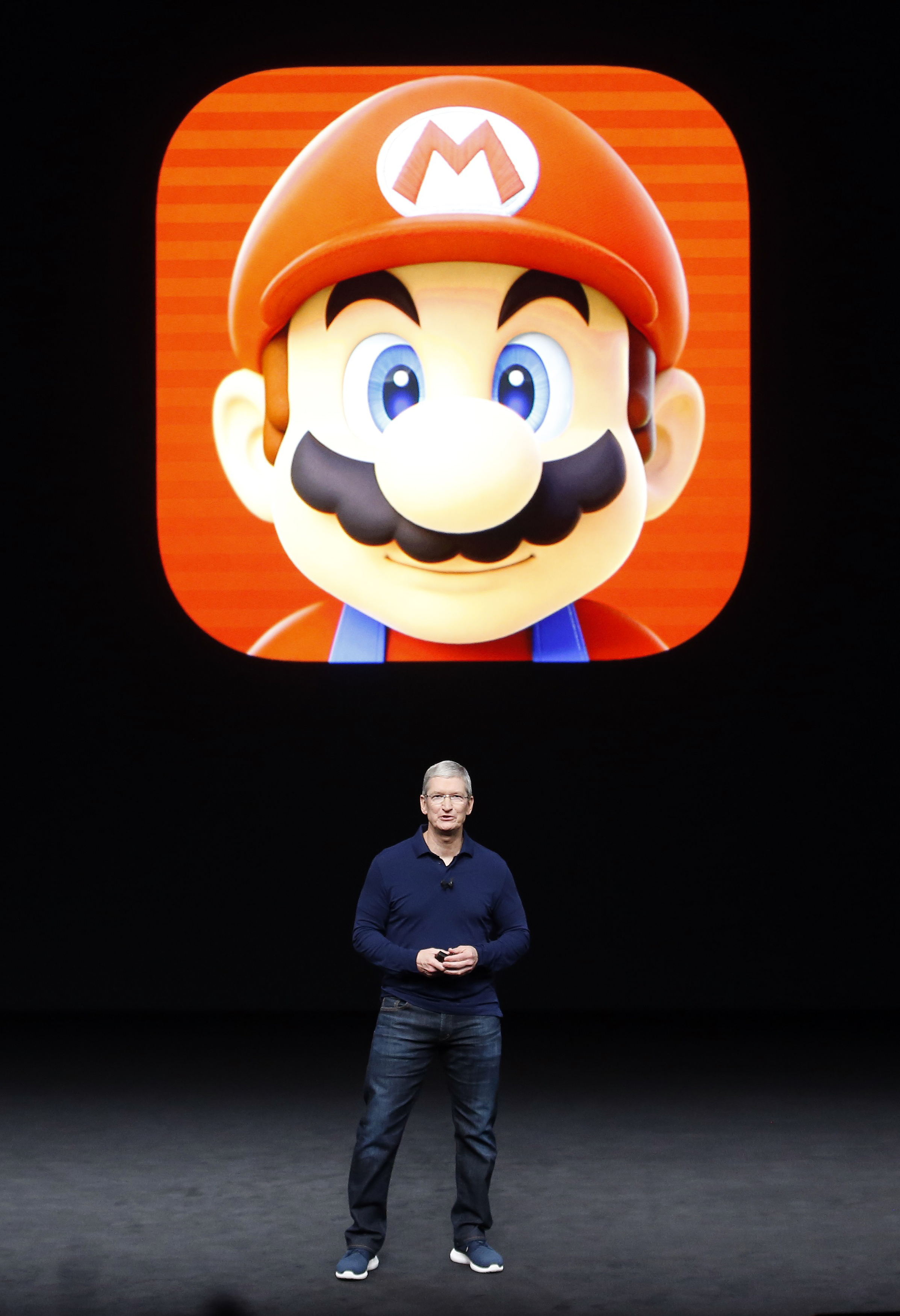 Tim Cook speaks in front of a Mario Bros. image during an Apple media event in San Francisco