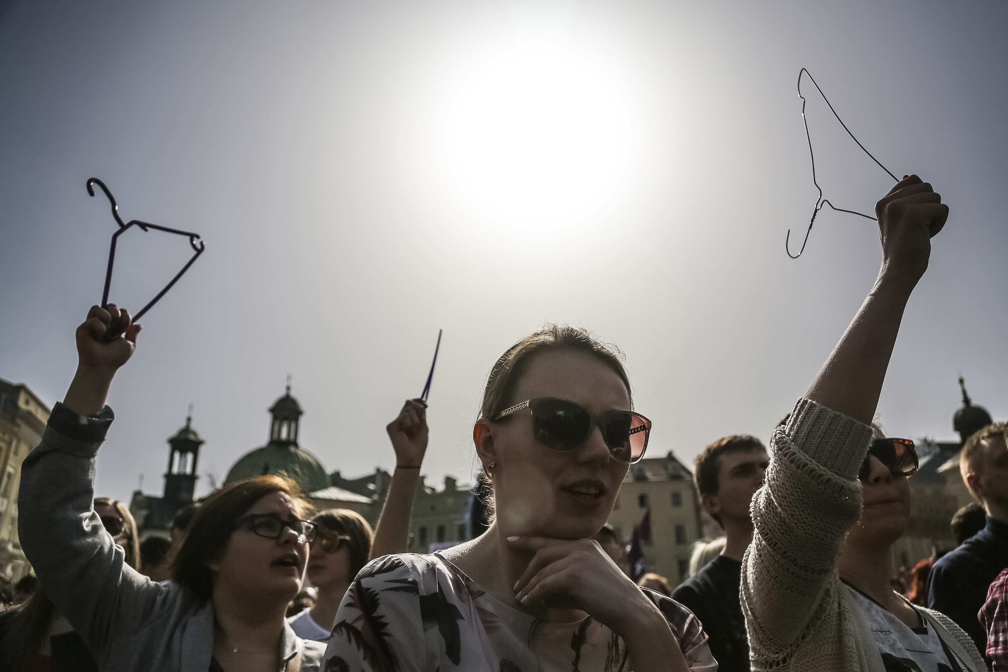 Women demonstrate with clothes hangers at the Main Square in
