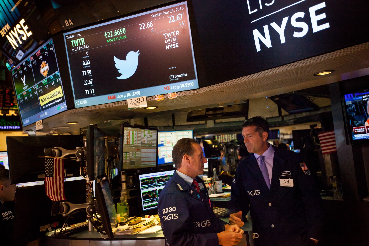 Stock traders work beneath a monitor displaying Twitter Inc. signage on the floor of the New York Stock Exchange (NYSE) in New York, U.S.