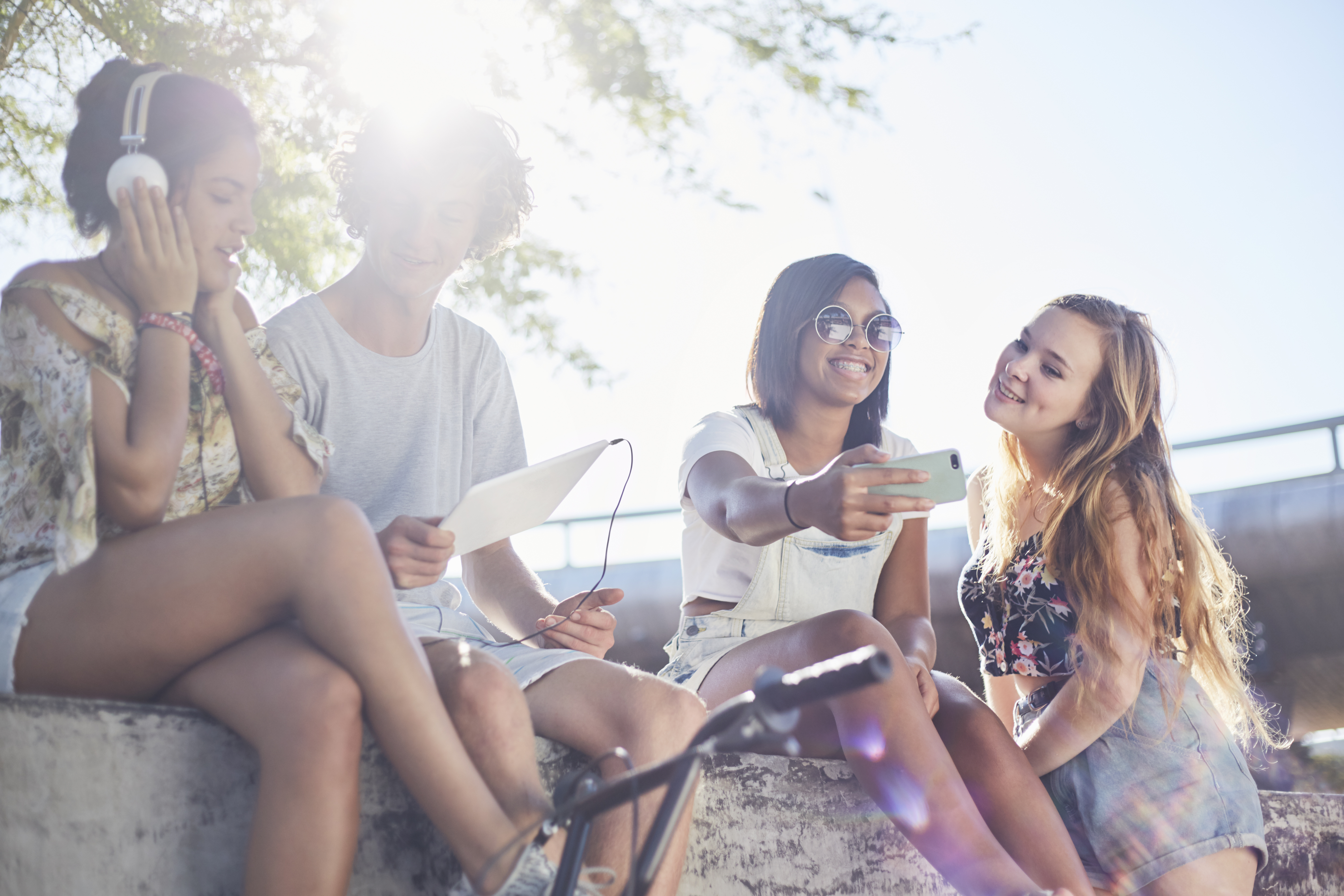 Teenage friends hanging out taking selfie and listening to music