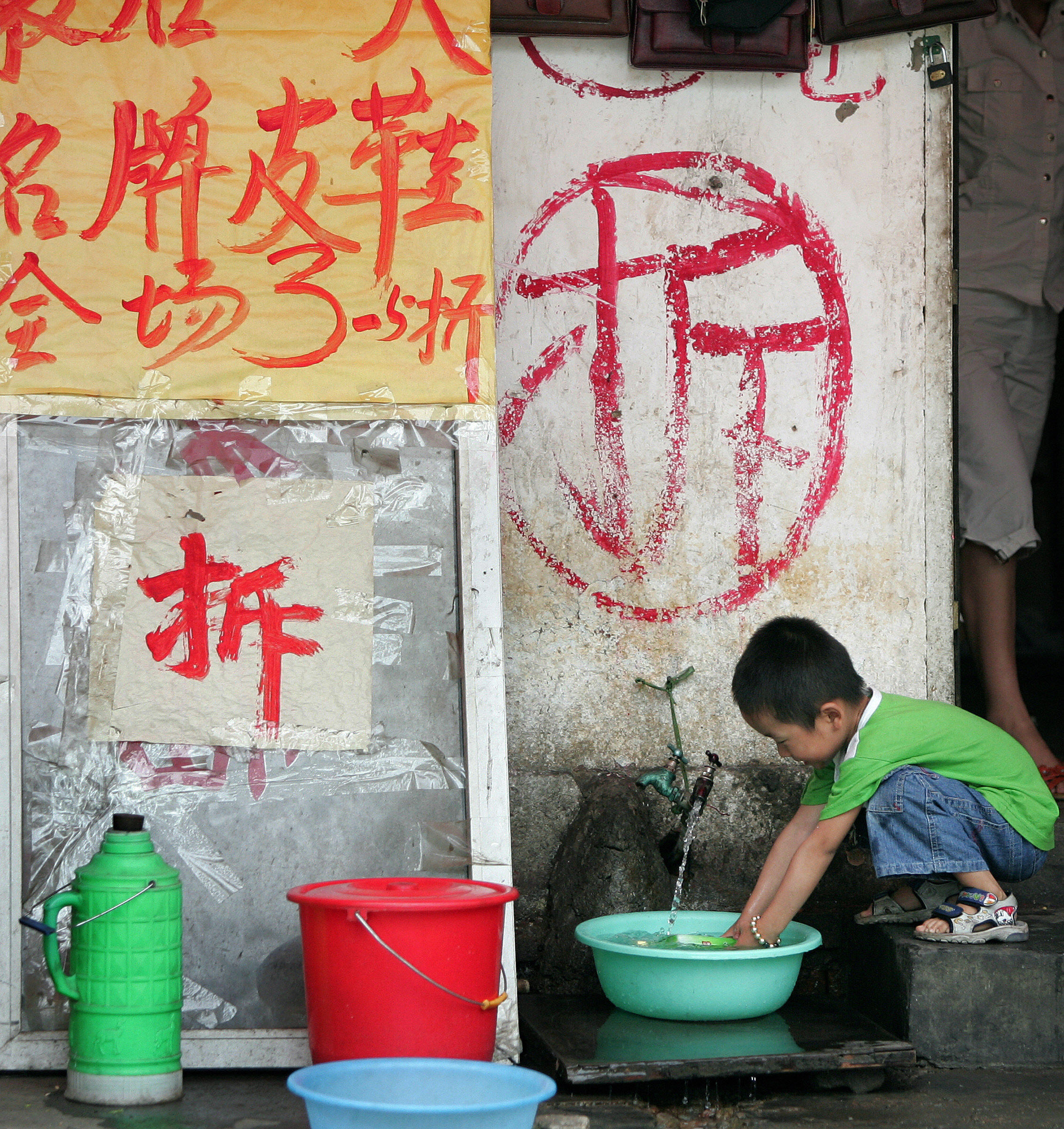A child fills a bottle with water runnin