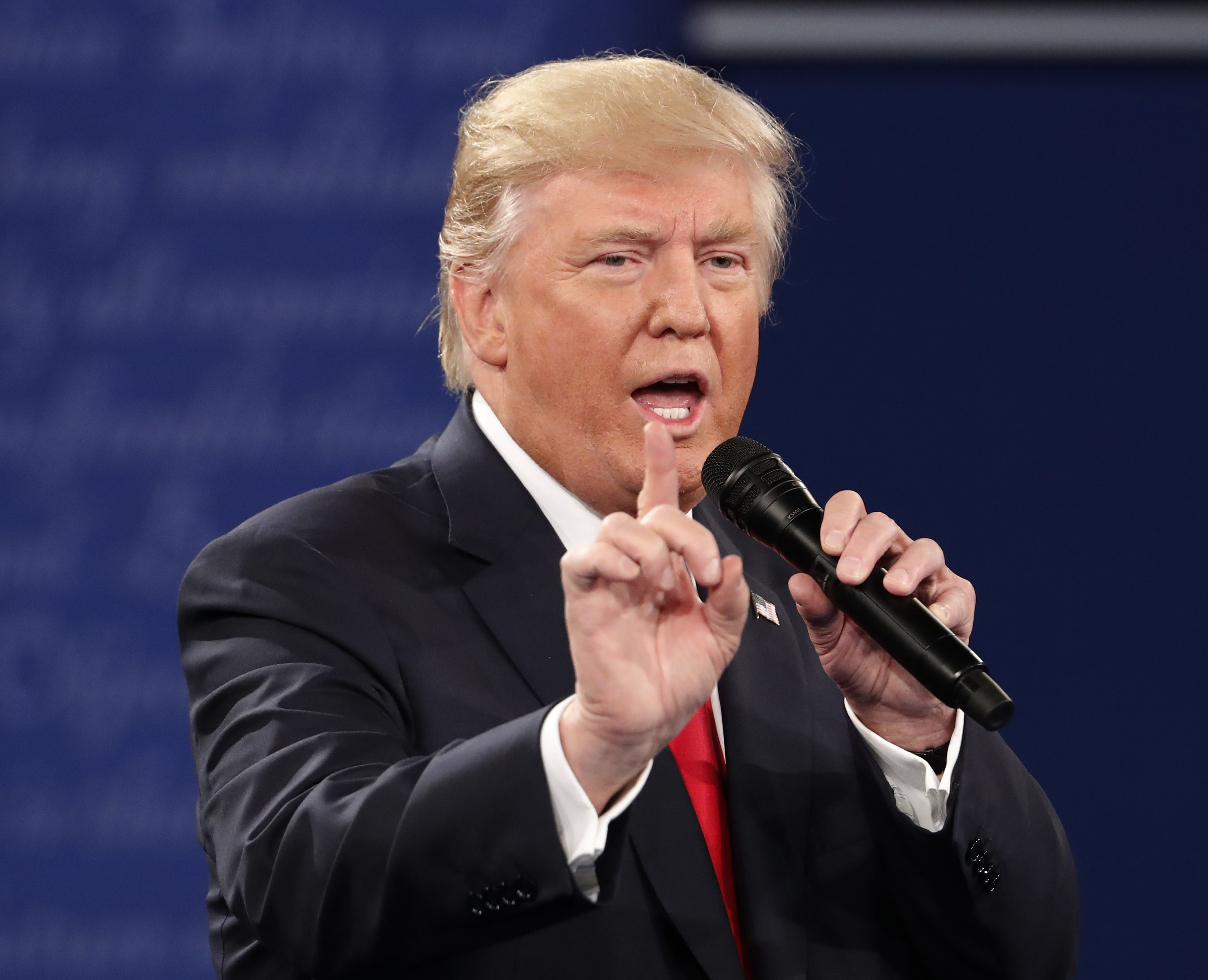 Republican U.S. presidential nominee Trump speaks as Democratic U.S. presidential nominee Clinton listens during their presidential town hall debate in St. Louis