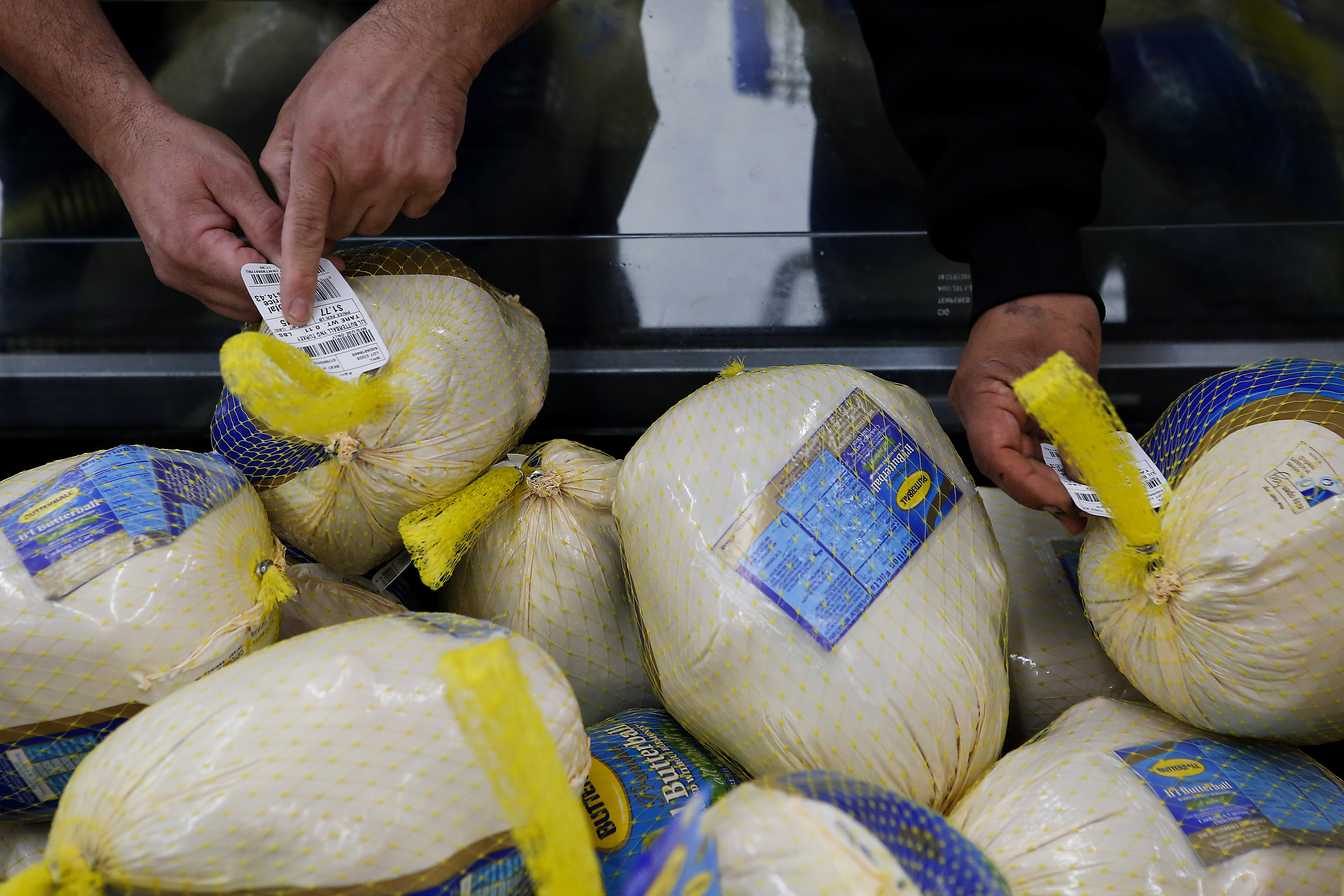 Customers check the price tag on a Butterball frozen turkey at a Walmart in Los Angeles.