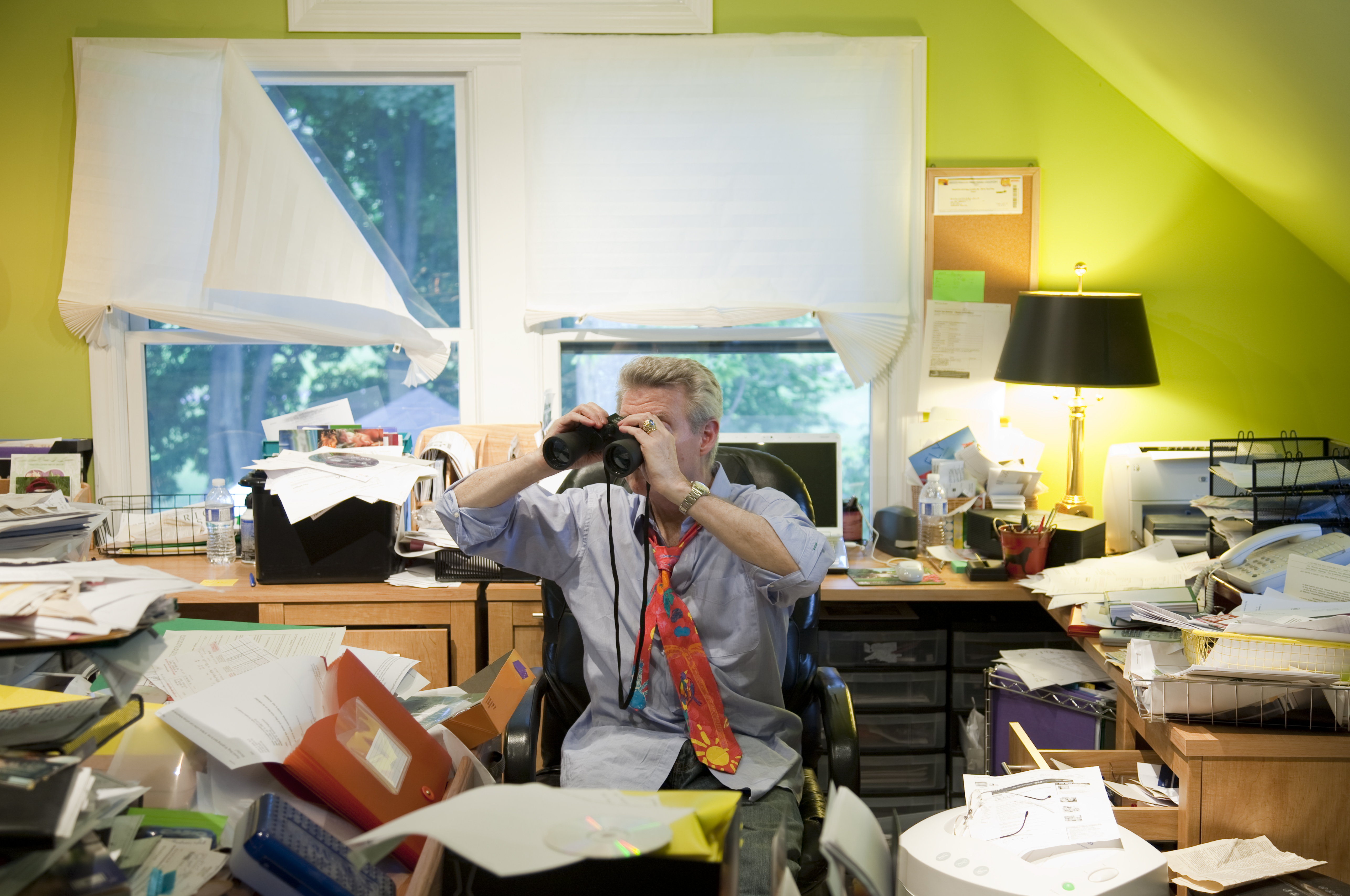 Baby Boomer w/ Binoculars in Messy Office