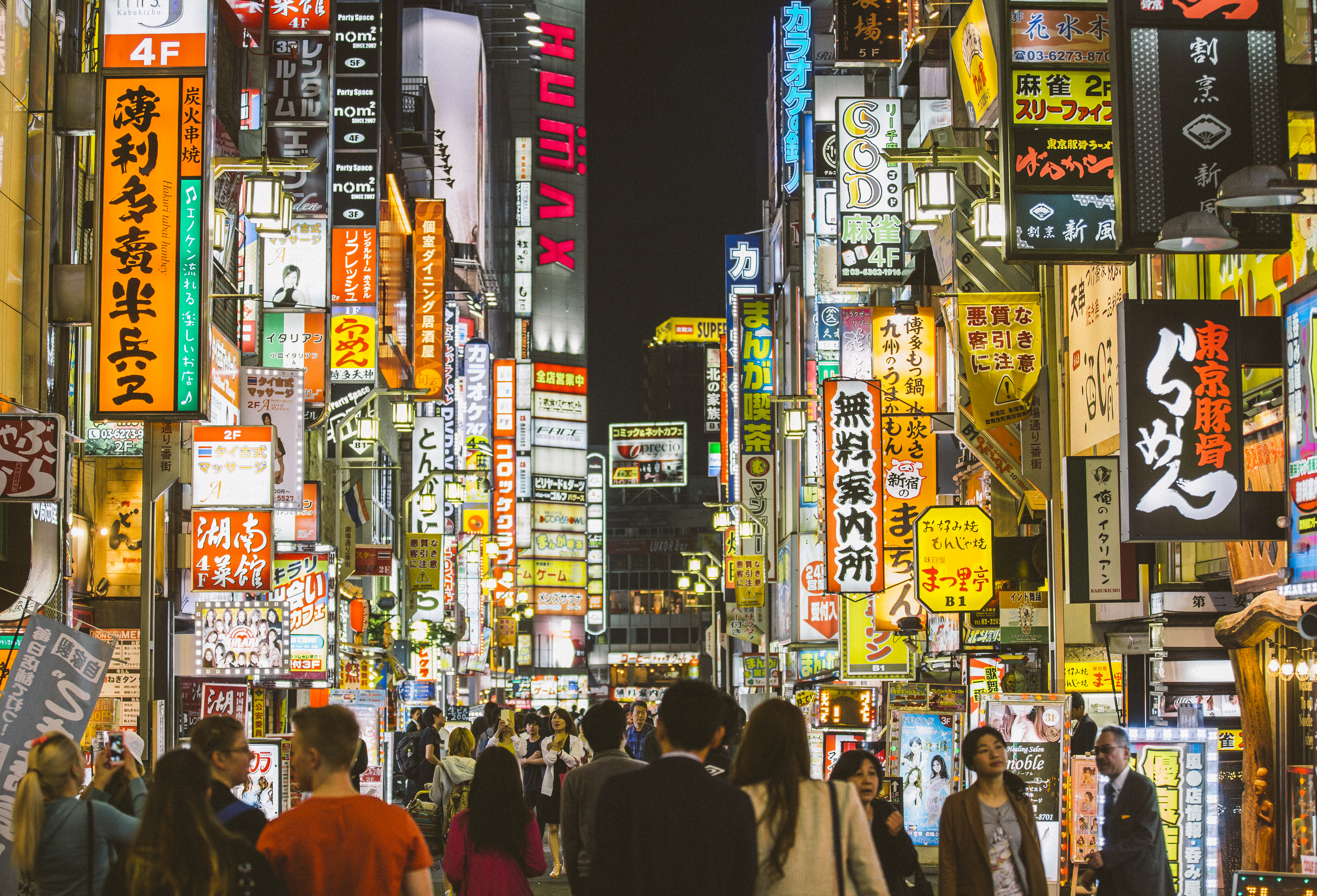 People walking among neon sign in Shinjuku, Tokyo