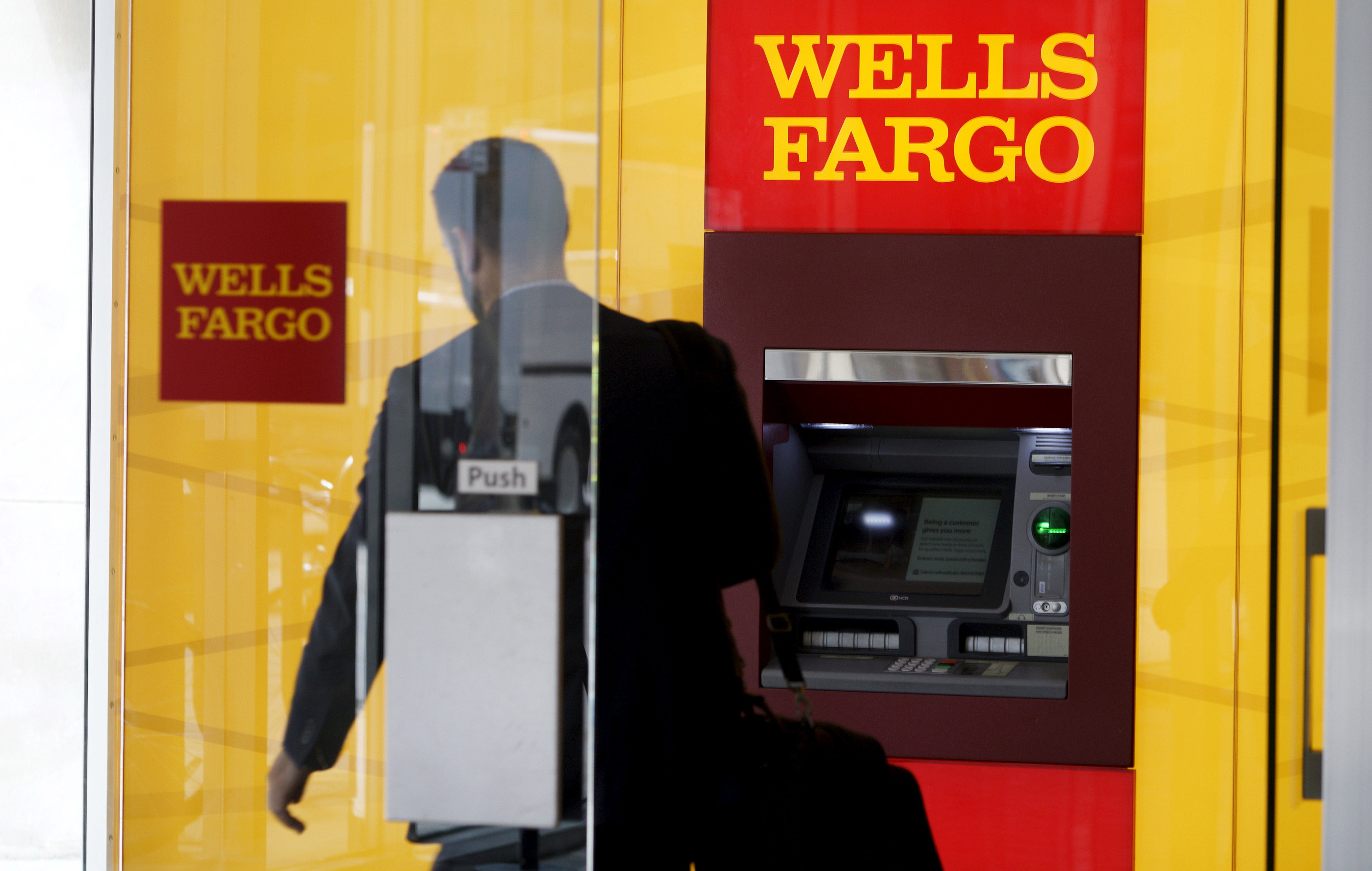 A man walks by a bank machine at the Wells Fargo & Co. bank in downtown Denver
