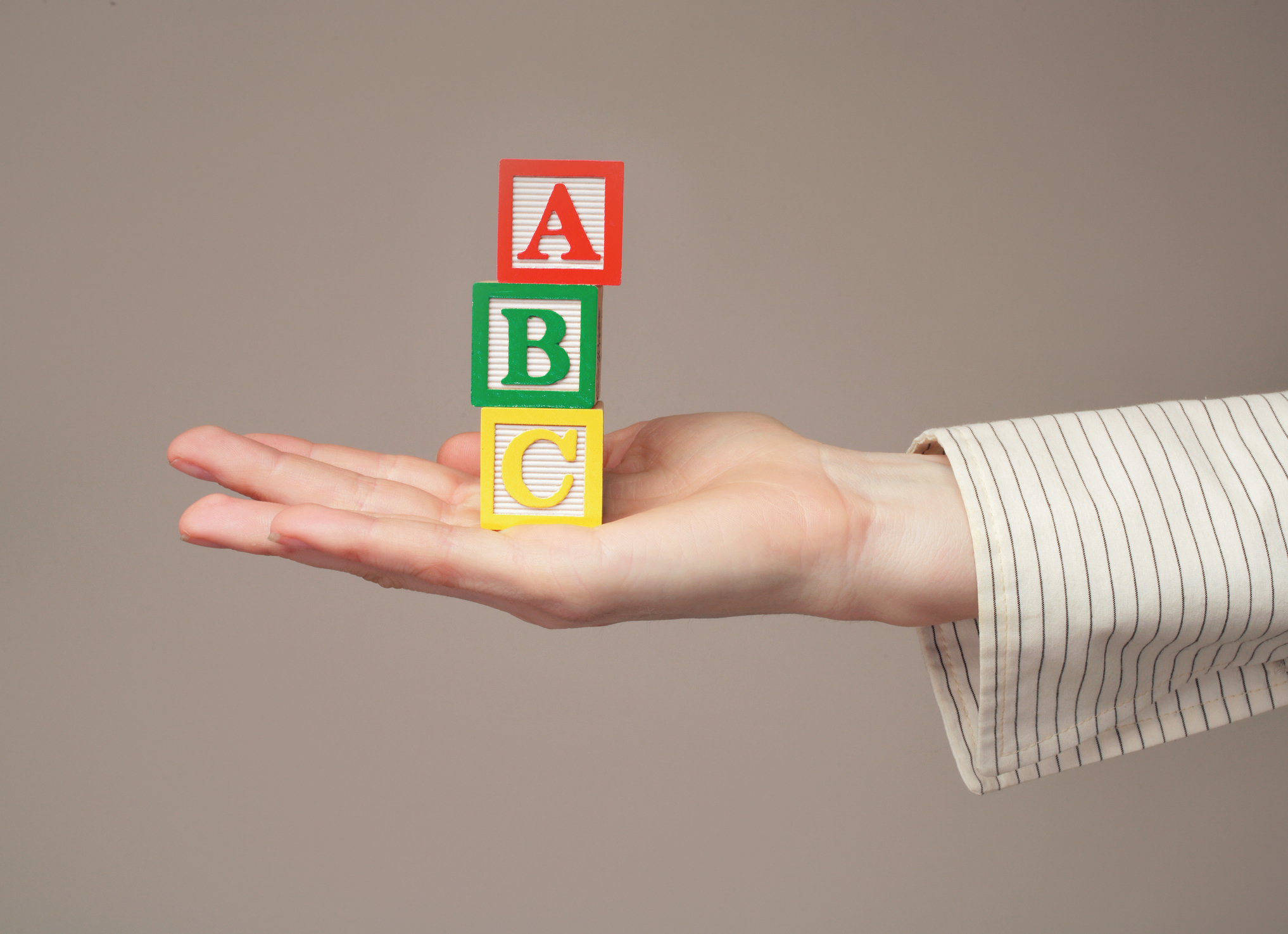 Woman holding out toy alphabet blocks, close-up