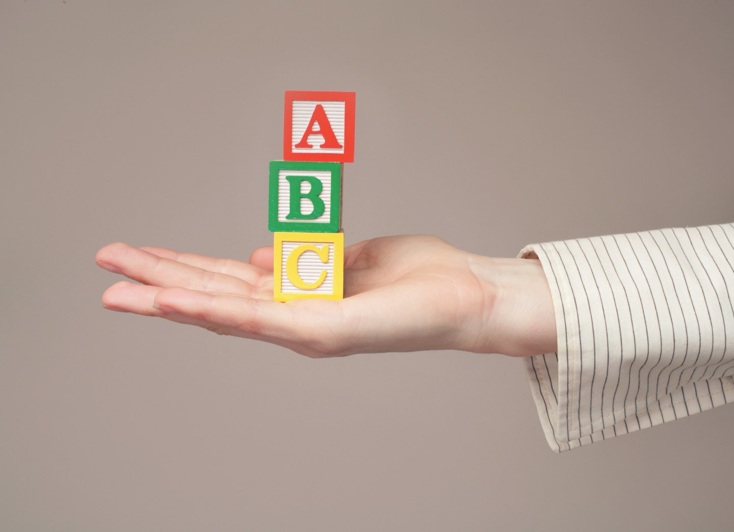 Woman holding out toy alphabet blocks, close-up