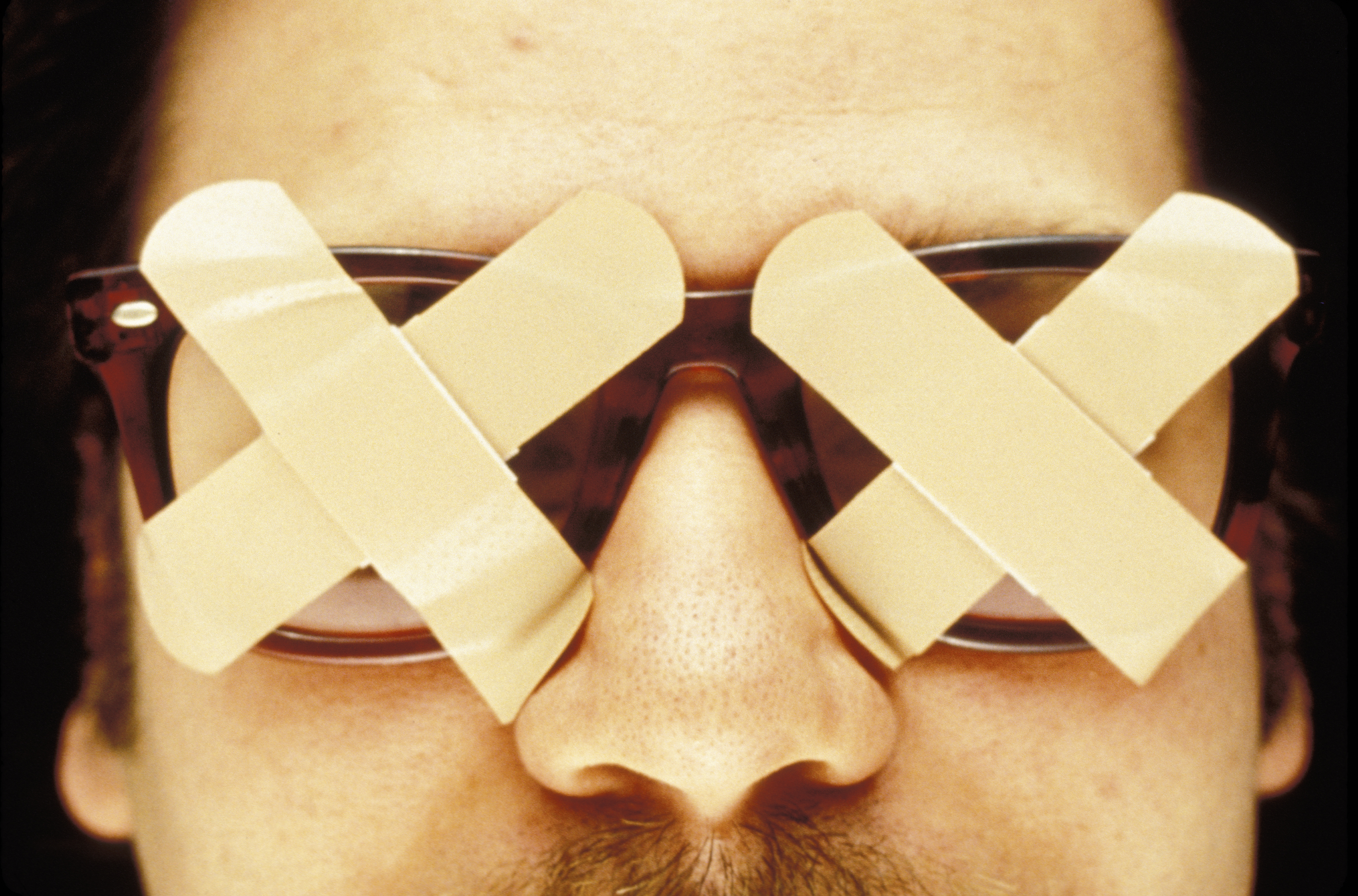Man wearing glasses covered with bandages