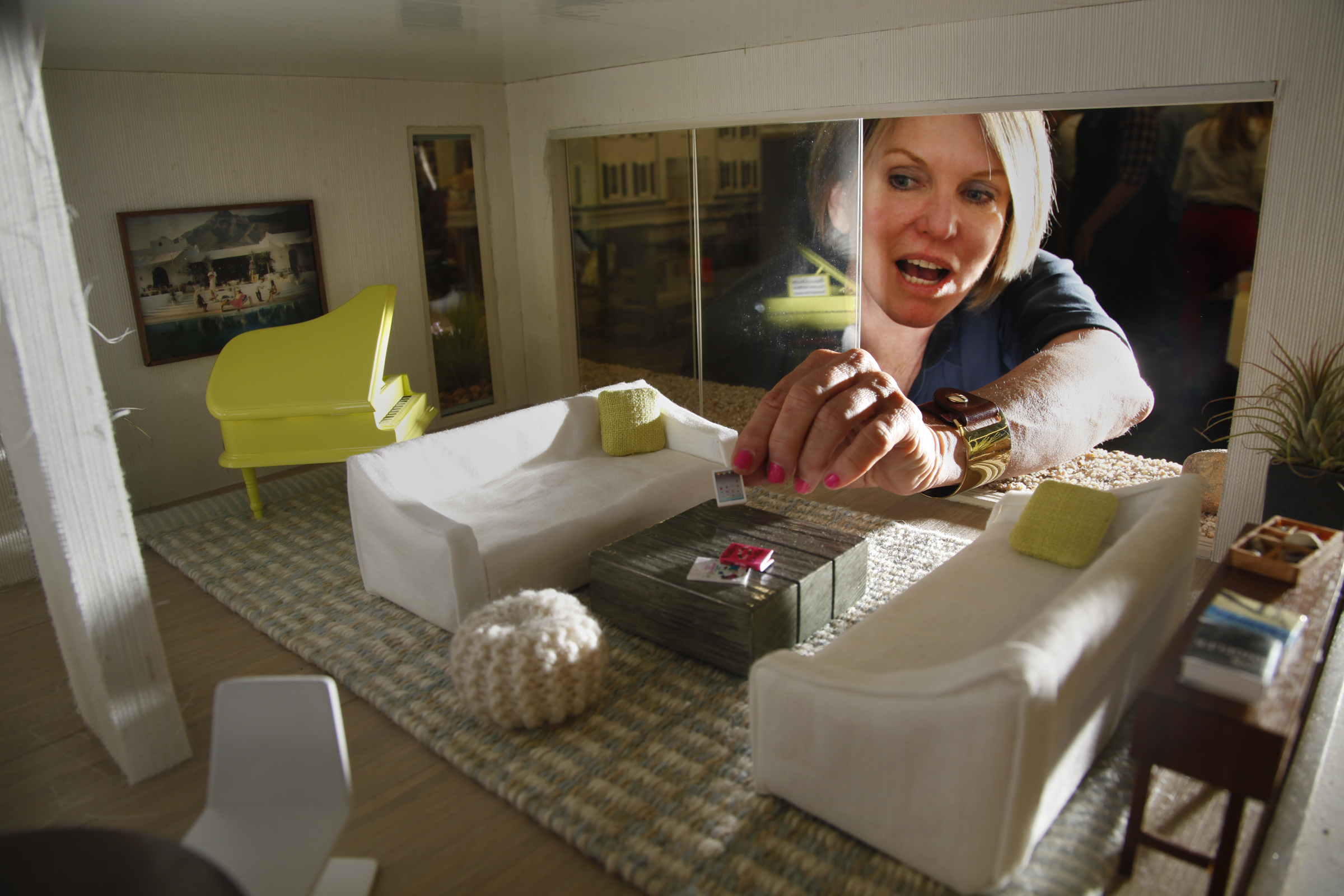 Interior designer Chris Barrett reaches through a sliding window wall in a contemporary beach dollh
