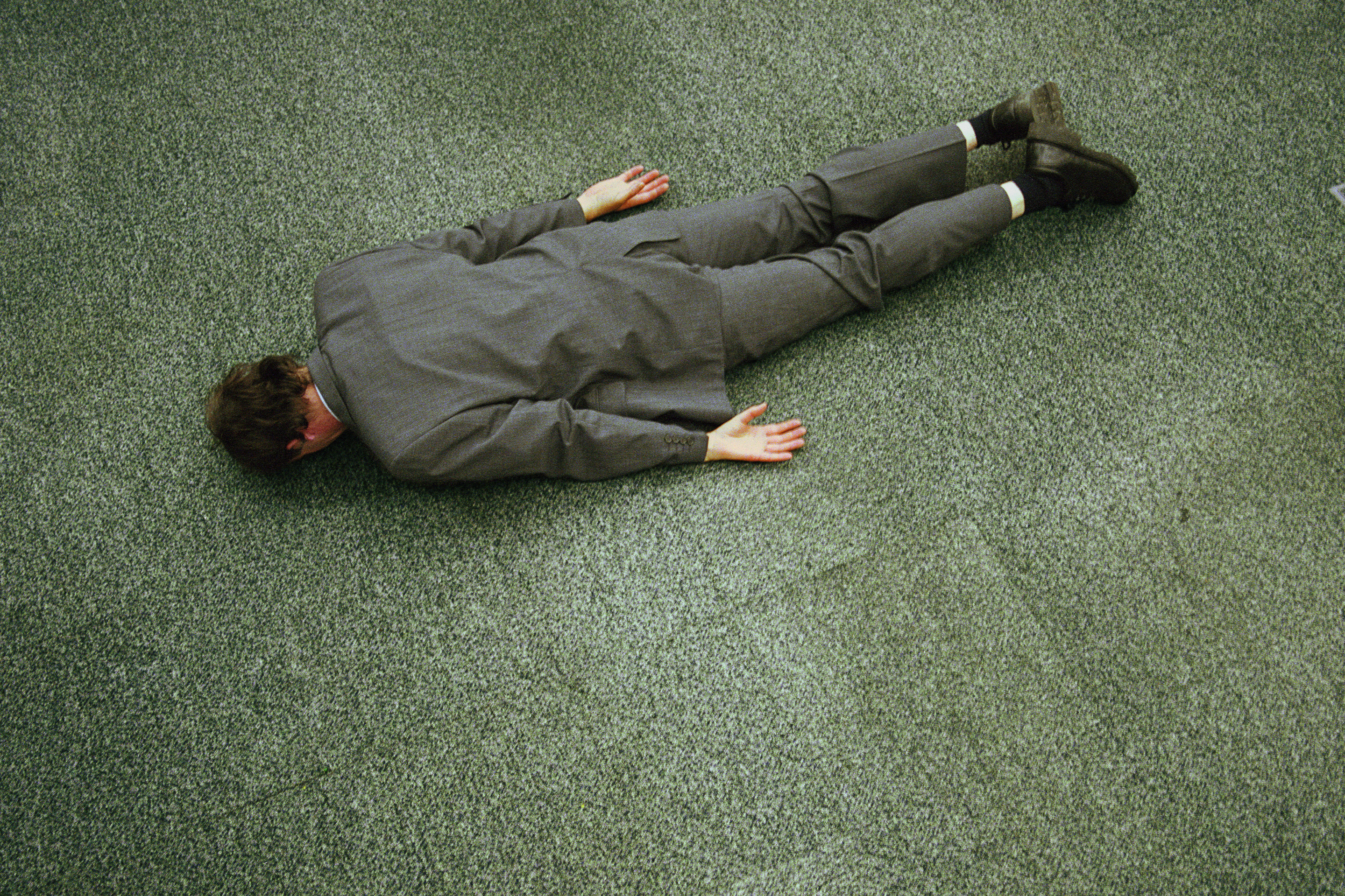 Businessman lying face down on floor, elevated view