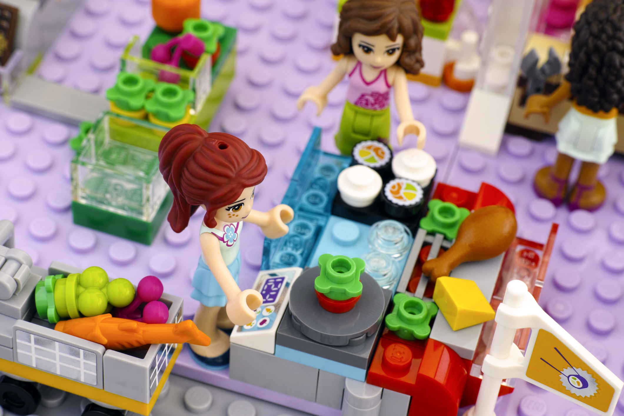 Lego girl in supermarket weighing vegetables