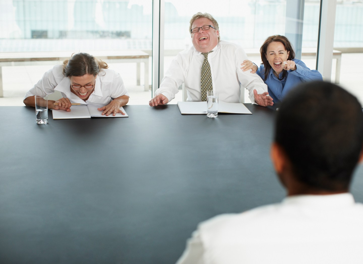 Businesspeople laughing at applicant in interview