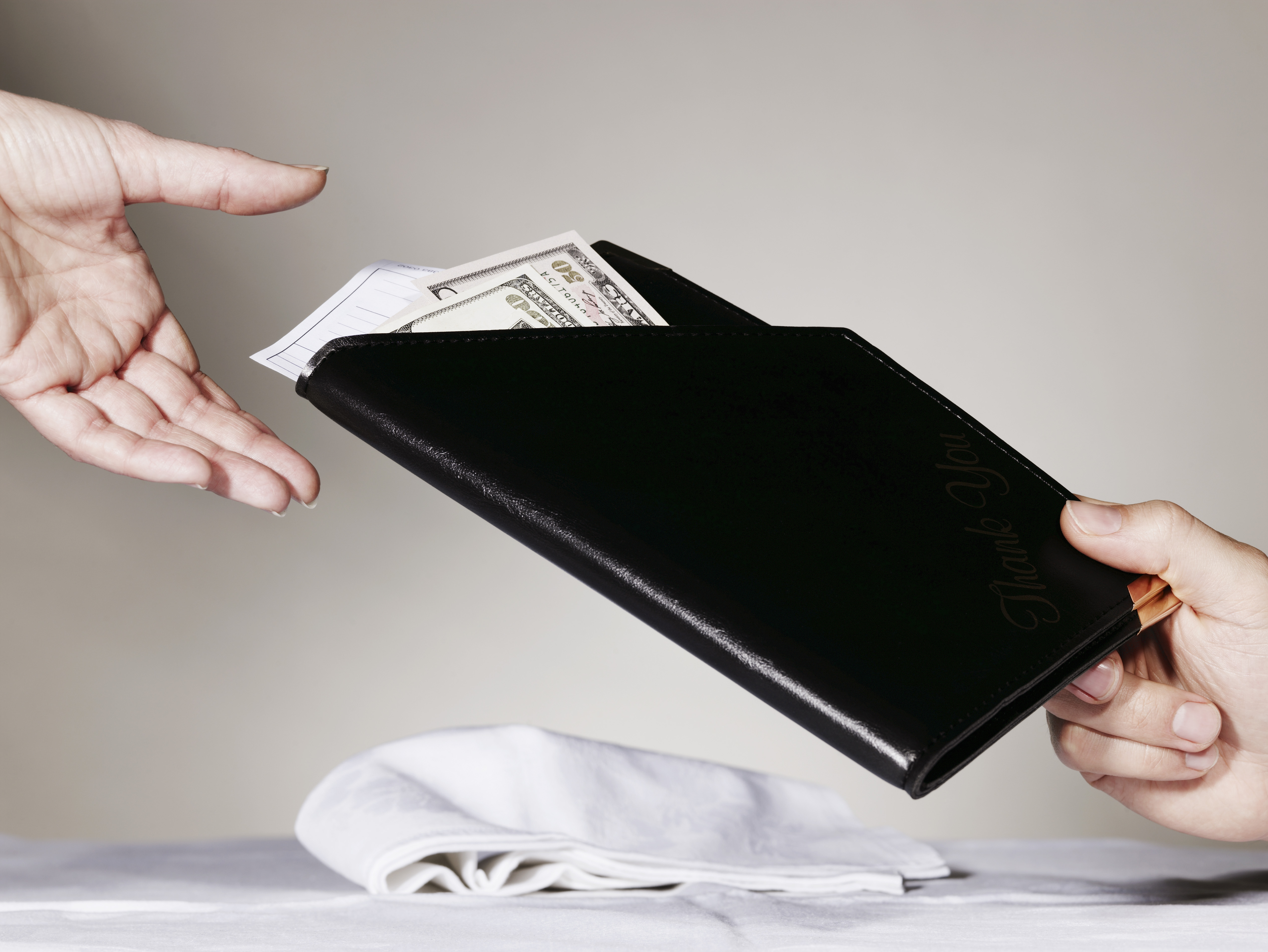 Person paying waiter for restaurant bill