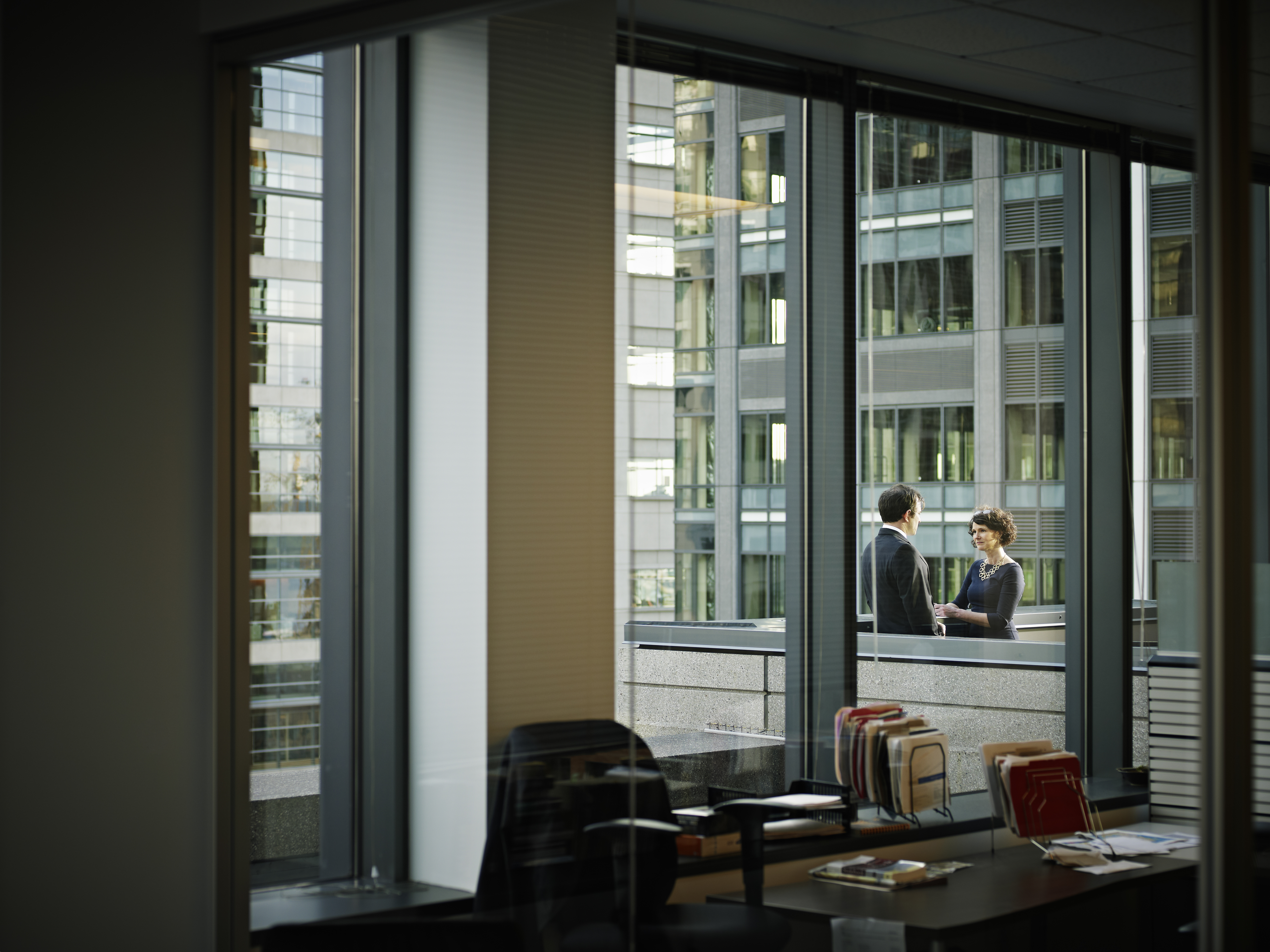 Coworkers in discussion on deck of office