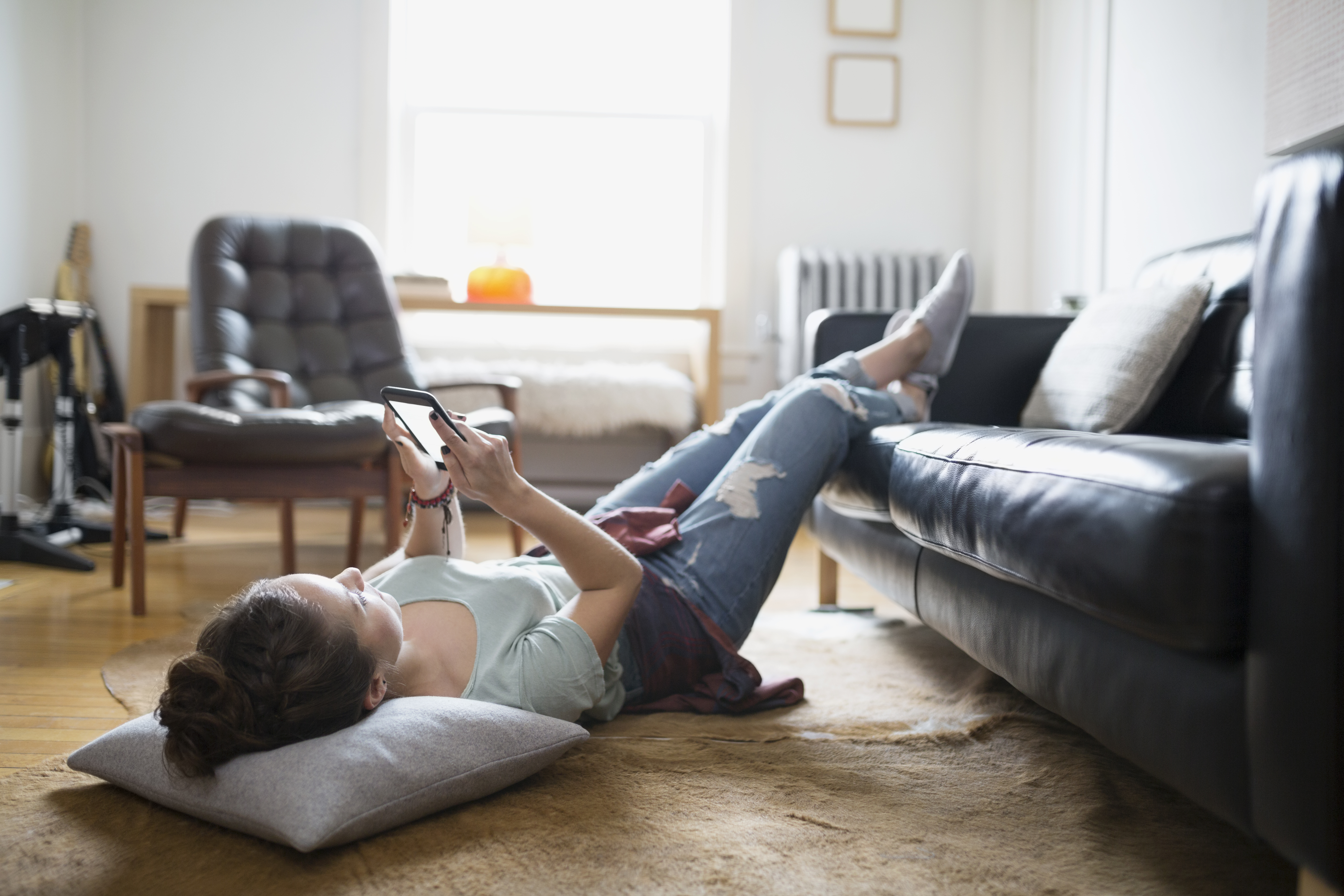 Woman laying with feet up texting