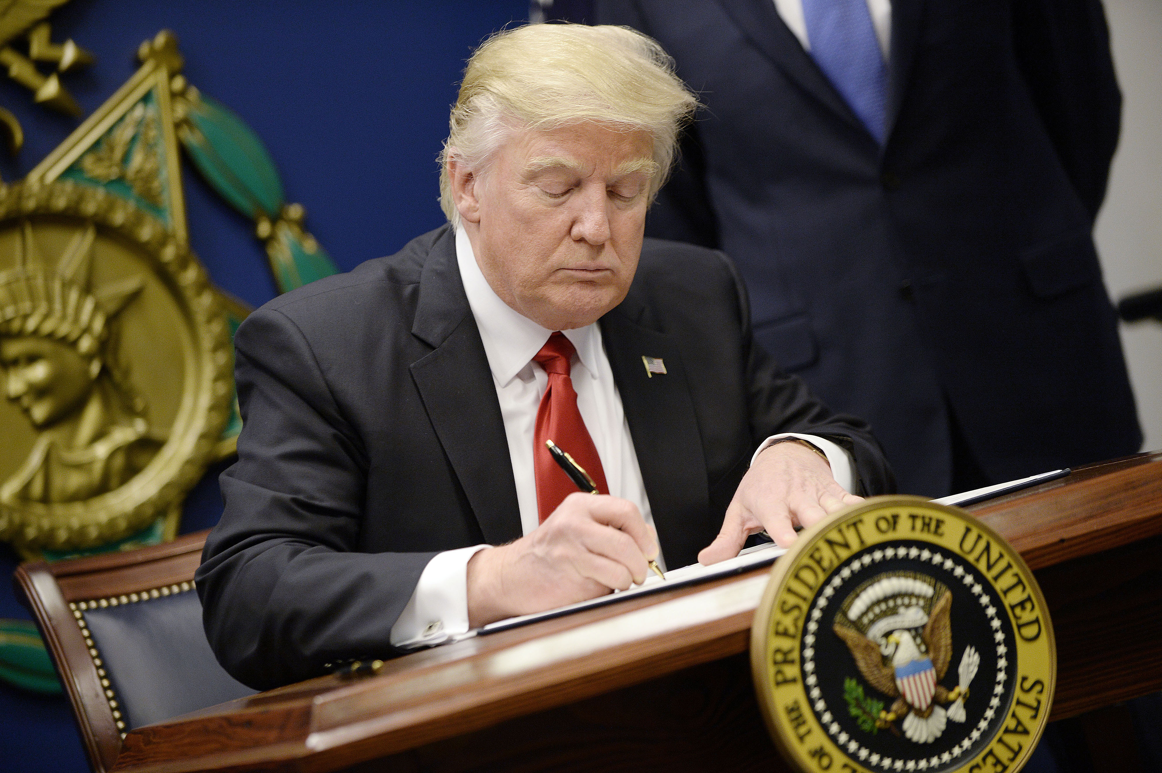 US President Donald Trump signs Executive Orders in the Hall of Heroes at the Department of Defense in Virginia, January 27, 2017.