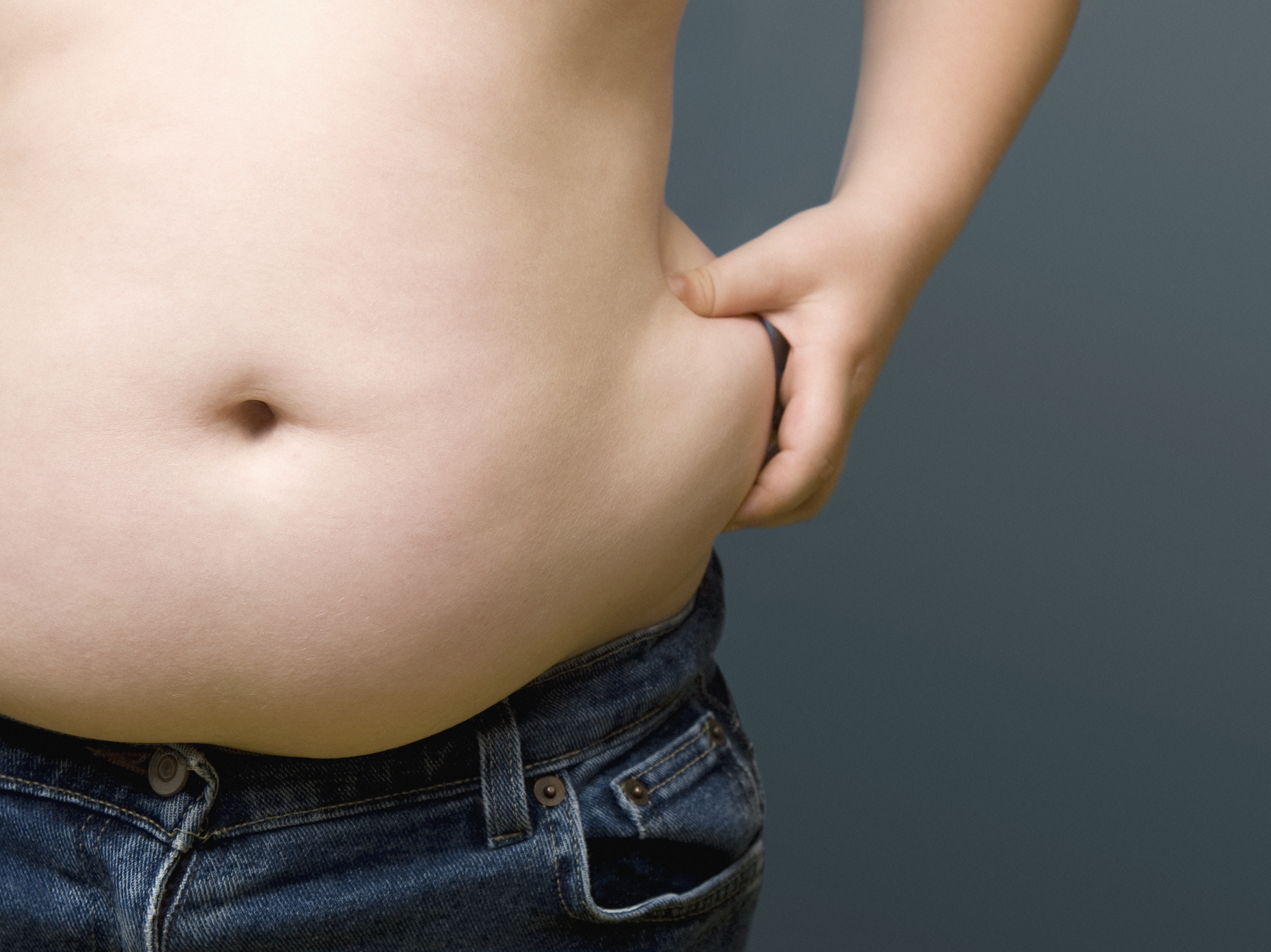 Boy (6-8) pinching fat