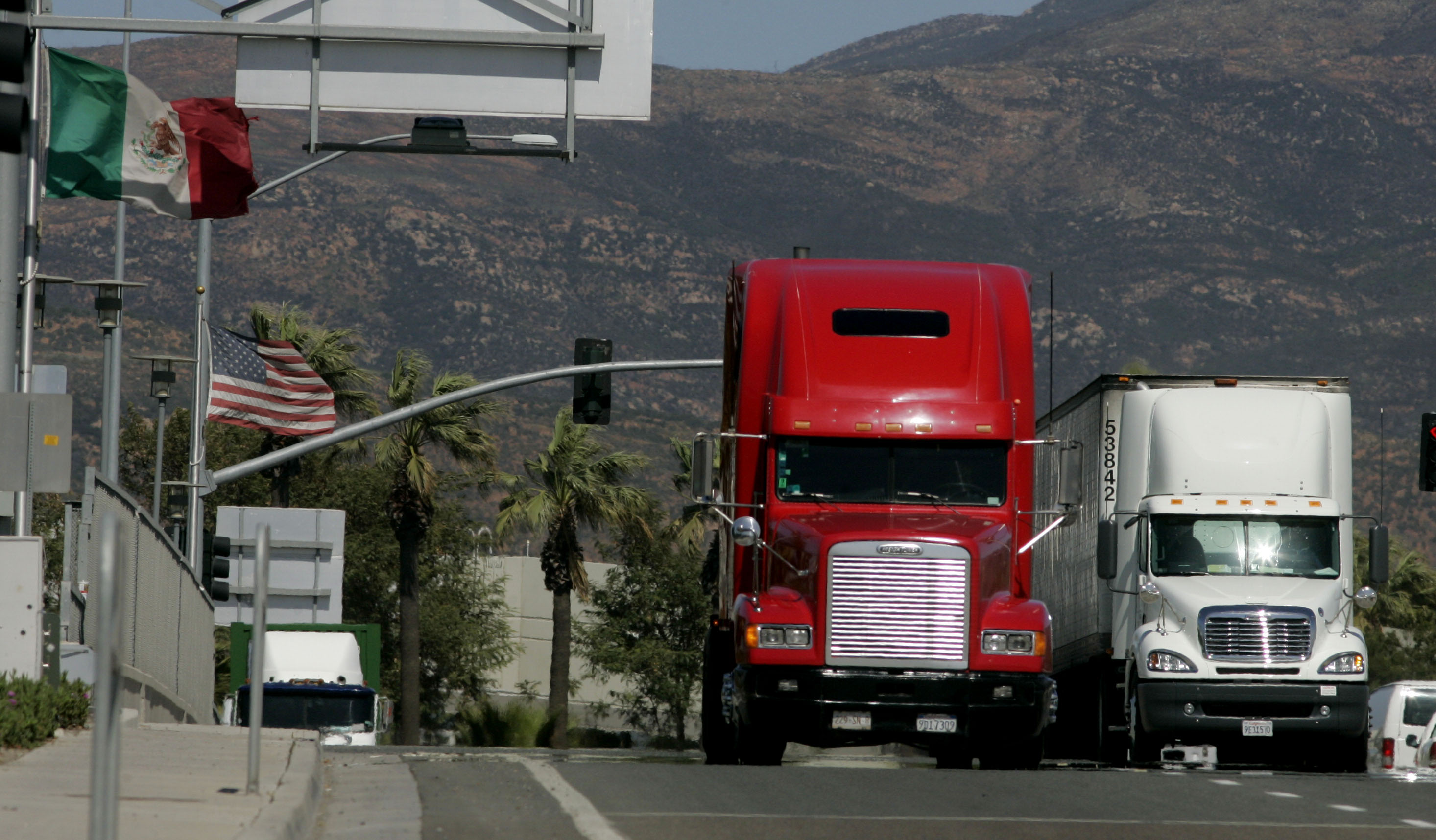 Trucks coming from Mexico prepare to enter the highway after crossing the border in California.