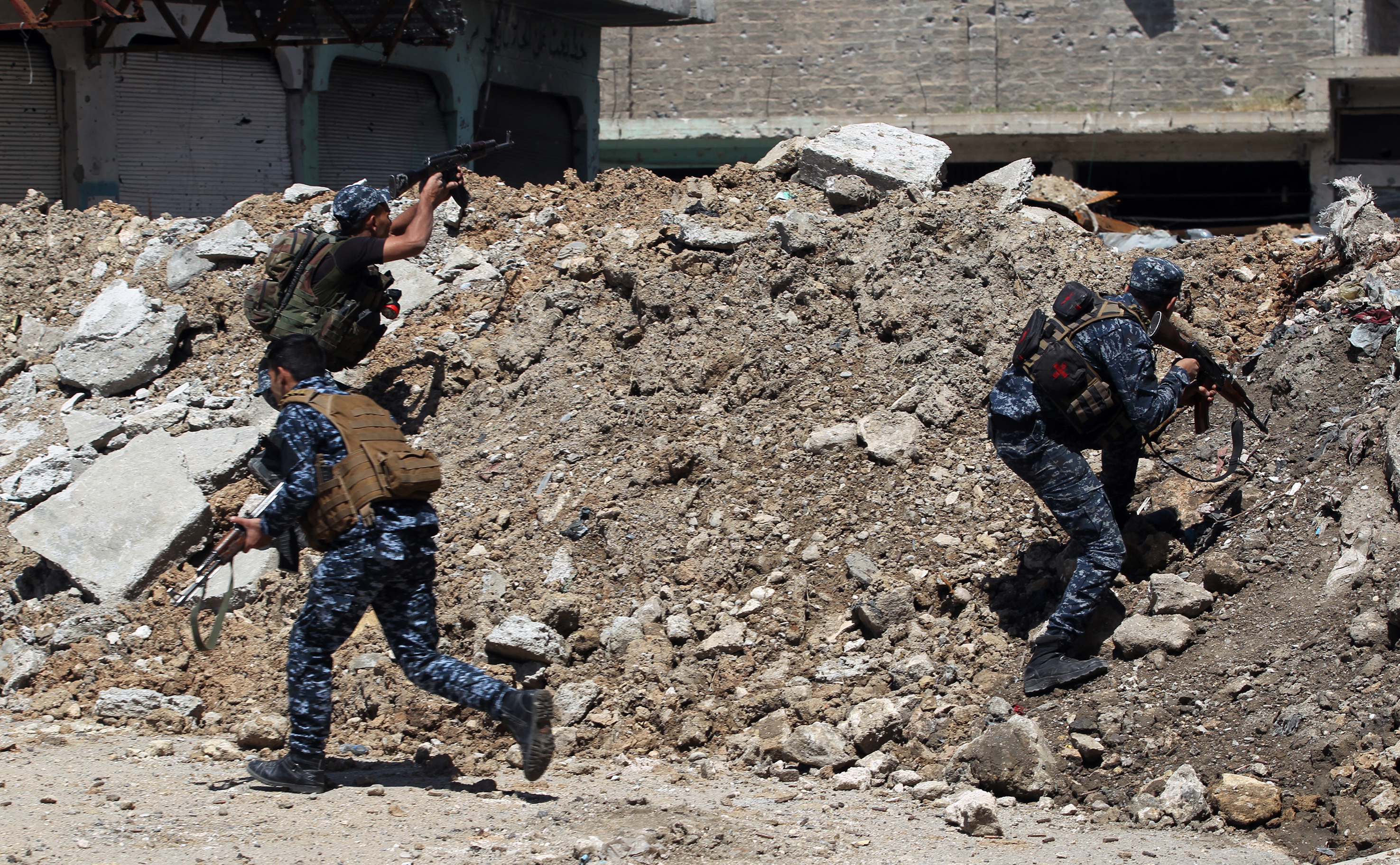 Members of the Iraqi shoot suppressive fire while taking cover behind a barrier made of debris in the old city of Mosul during the offensive to recapture the city from Islamic State (IS) group fighters, on April 16, 2017. / AFP PHOTO / AHMAD AL-RUBAYE (Photo credit should read AHMAD AL-RUBAYE/AFP/Getty Images)