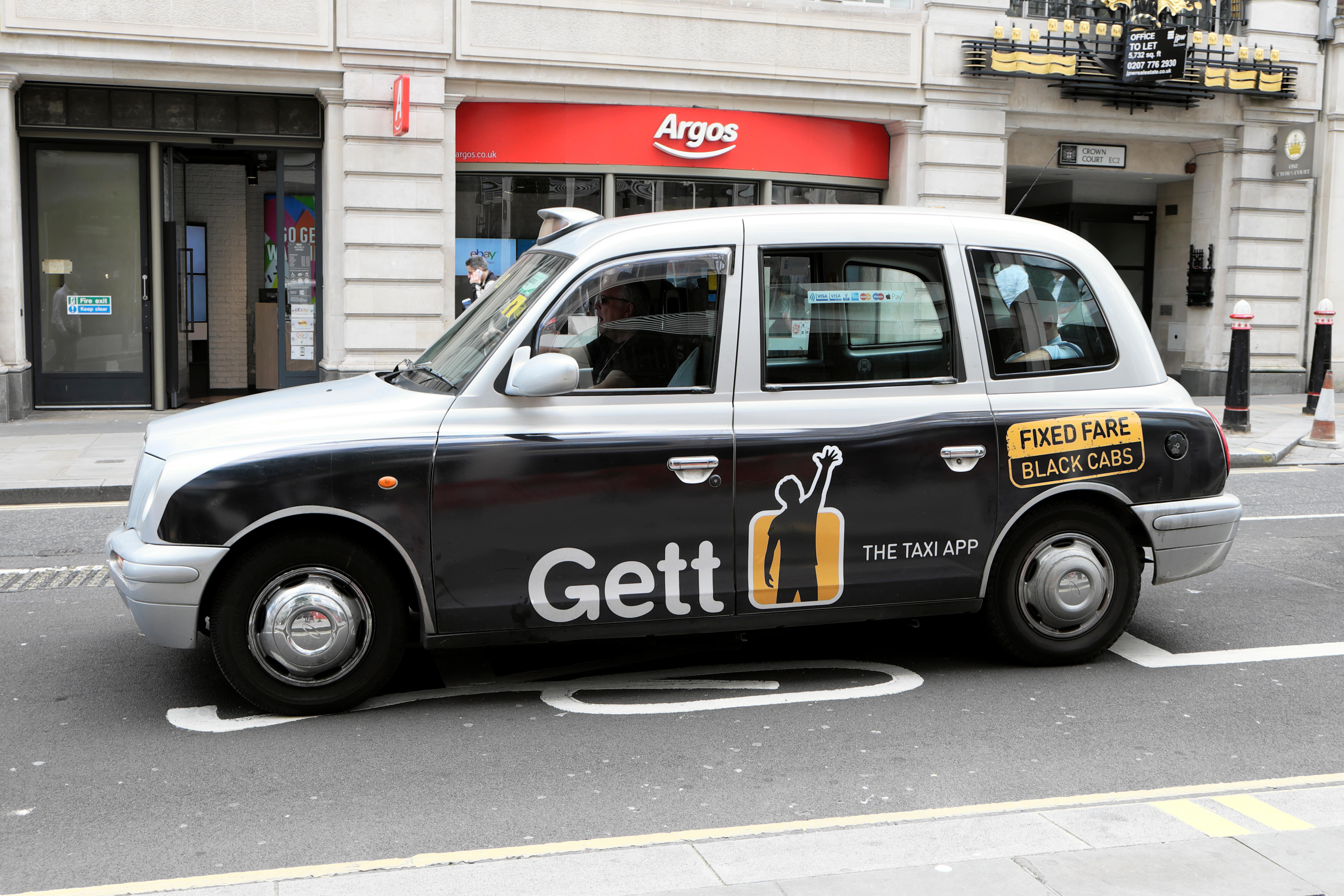 Gett app "fixed fare" advert advertisement on black taxi cab in street Cheapside, London UK KATHY DEWITT