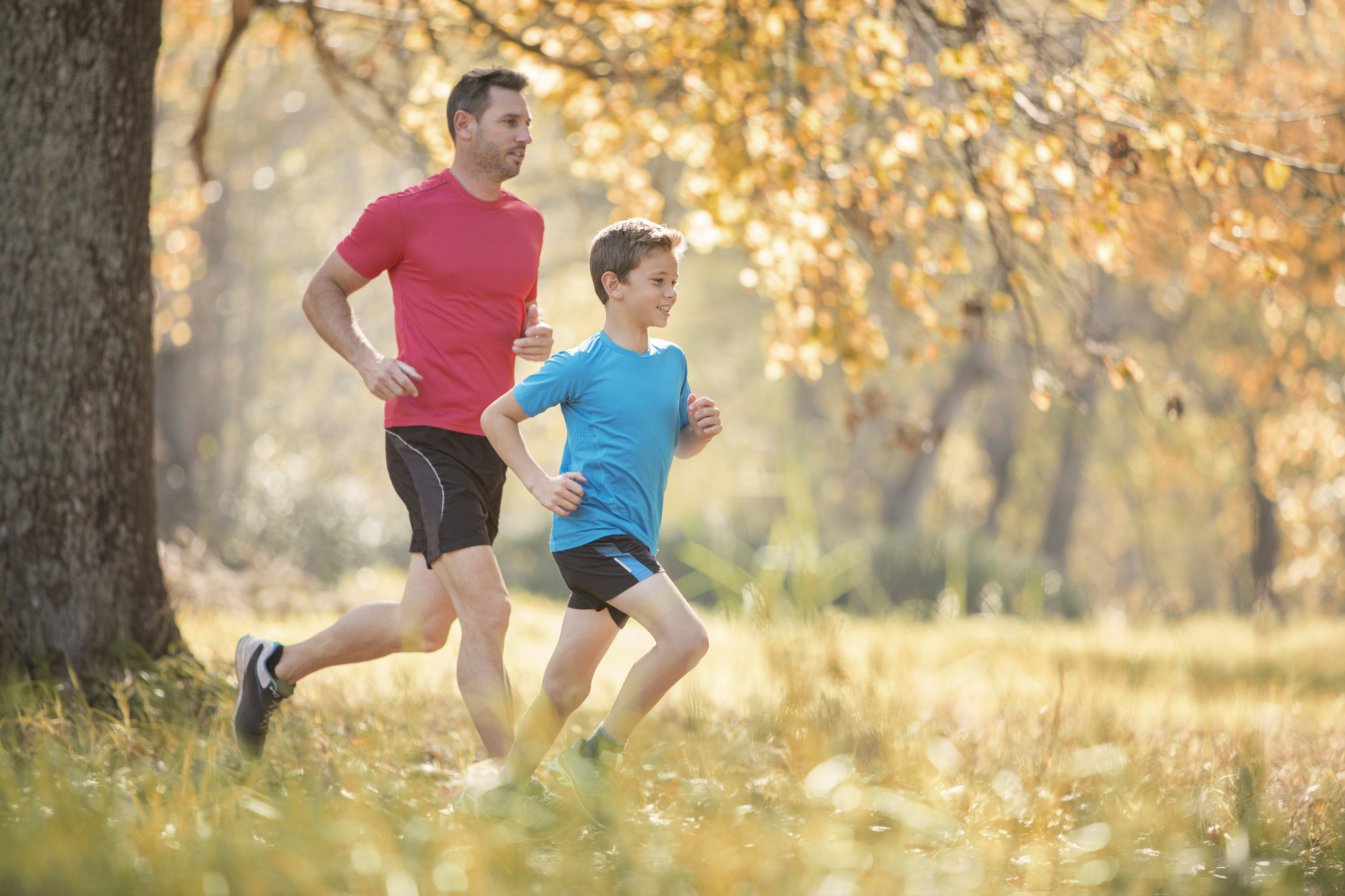Father and son jogging in autumn park