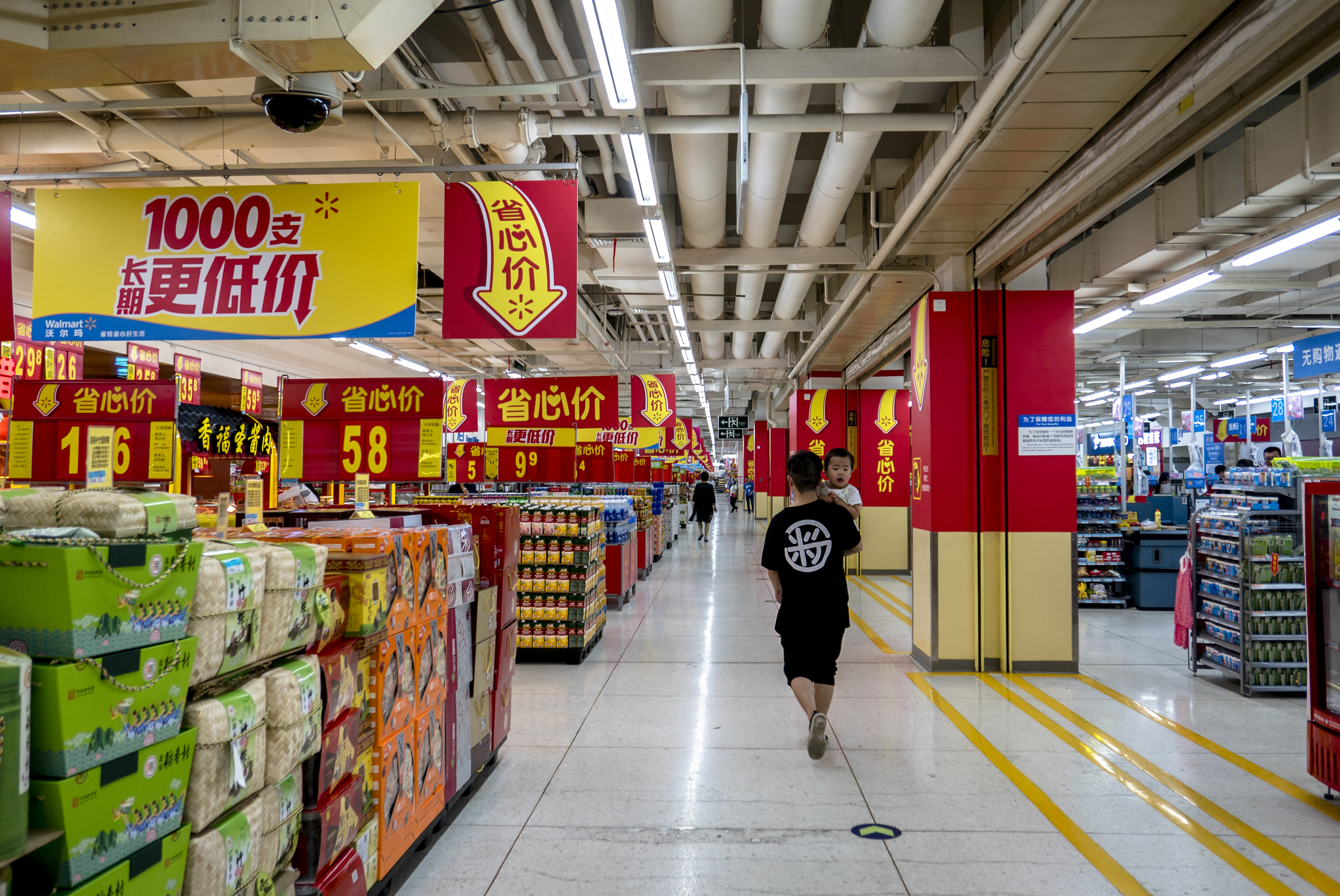 A father hugging his son walks in a Walmart supermarket.