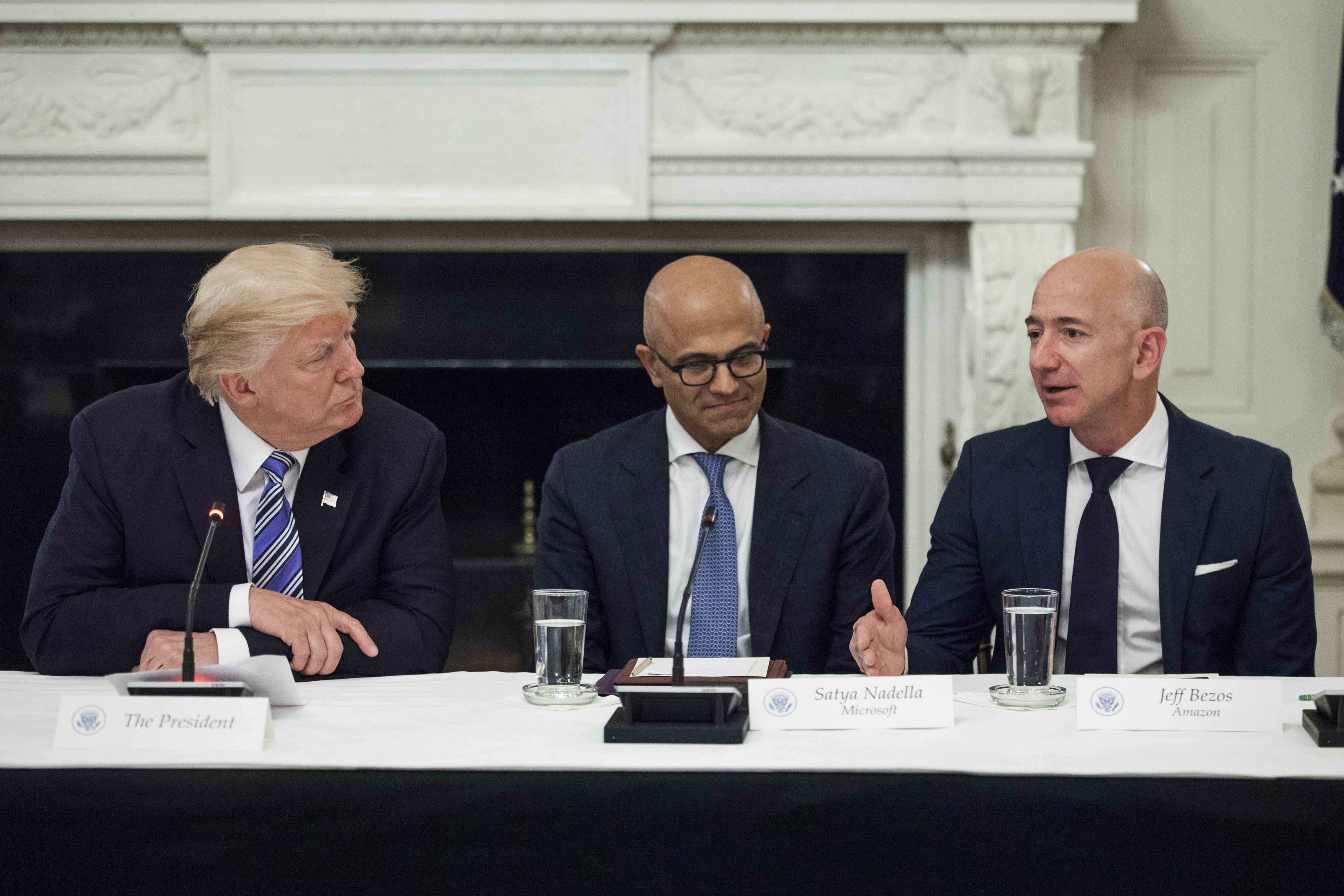 Jeff Bezos, president and chief executive officer of Amazon.com Inc., right, speaks as U.S. President Donald Trump, left, and Satya Nadella, chief executive officer of Microsoft Corp., listen during the American Technology Council roundtable hosted at the White House in Washington, D.C., U.S., on Monday, June 19, 2017. Executives from many of the world's largest technology companies gathered for the first meeting of the American Technology Council with Trump and his senior advisers. Photographer: Zach Gibson/Bloomberg via Getty Images