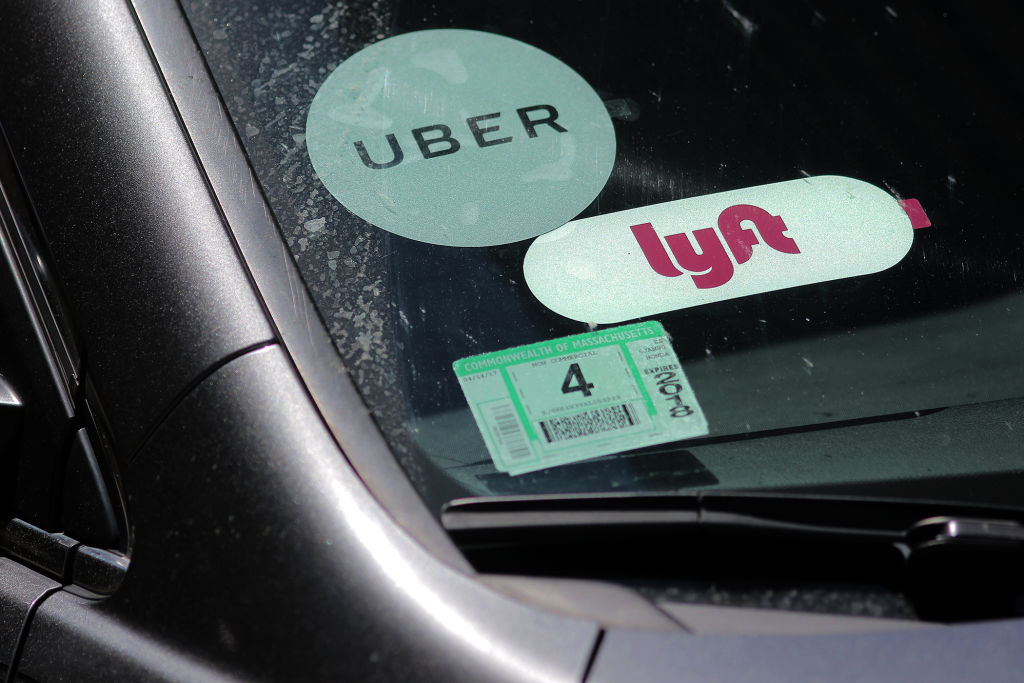 Boston, MA - 06/15/17 - A driver with placards for both Lyft and Uber waits for a traffic light outside South Station after picking up a passenger. Will Lyft benefit from the current corporate travails of competitor Uber? (Lane Turner/Globe Staff) Reporter: (Adam Vaccaro) Topic: (16lyft)