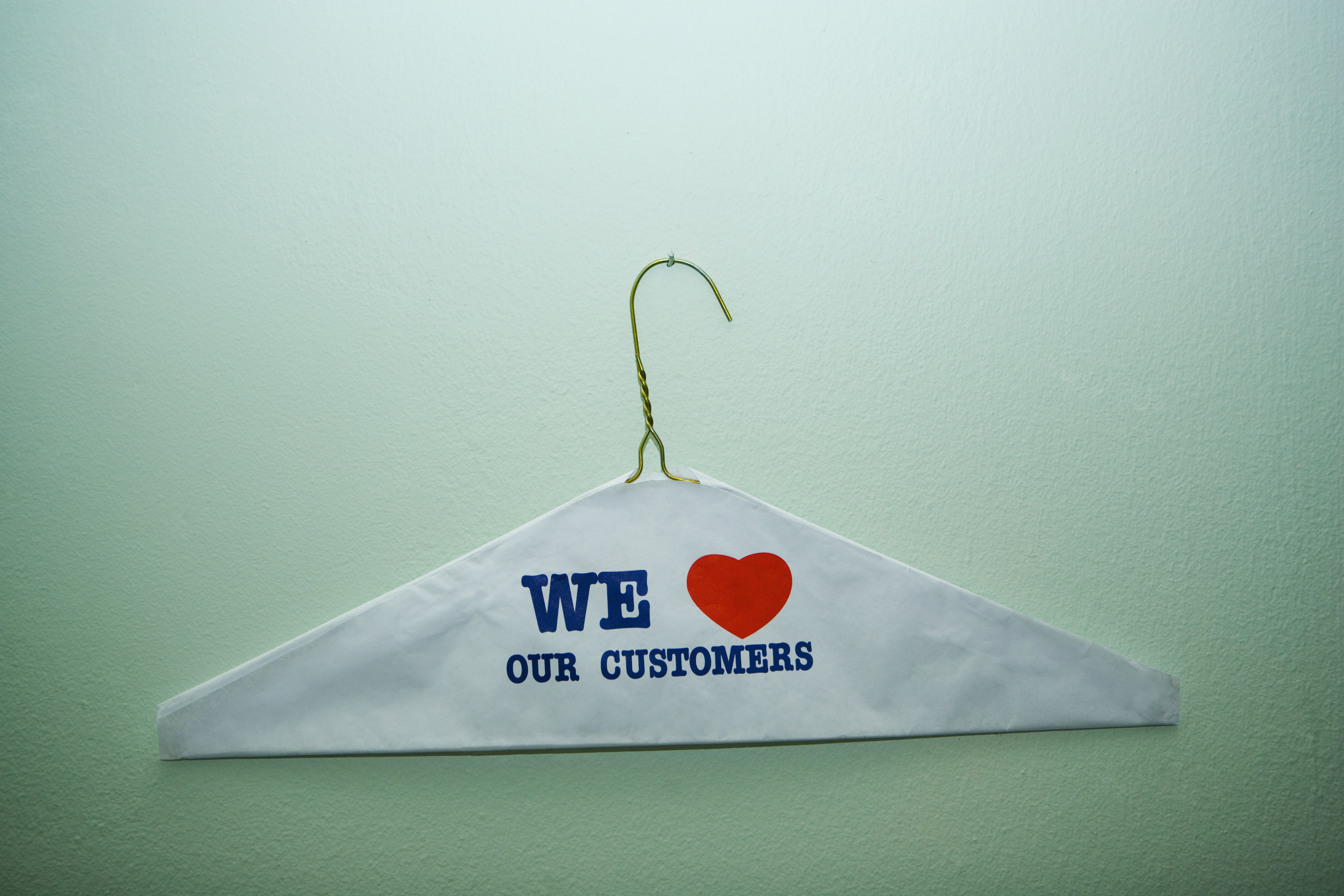 Close-up of text We Love Our Customer painted on a cloth on a hanger, New York City, New York State, USA