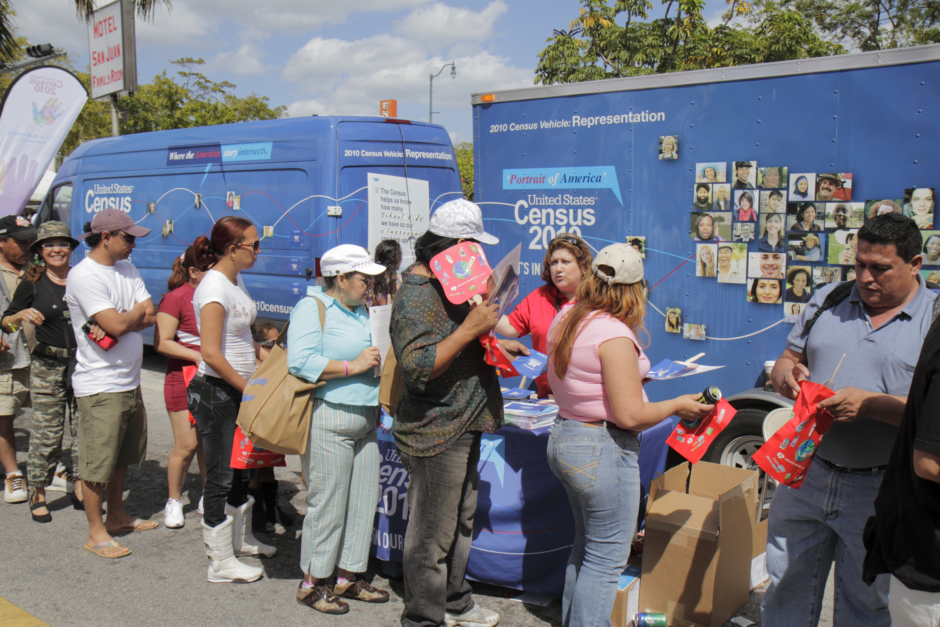 Men and women queuing at Carnaval Miami passing the Census 2010 information stand.