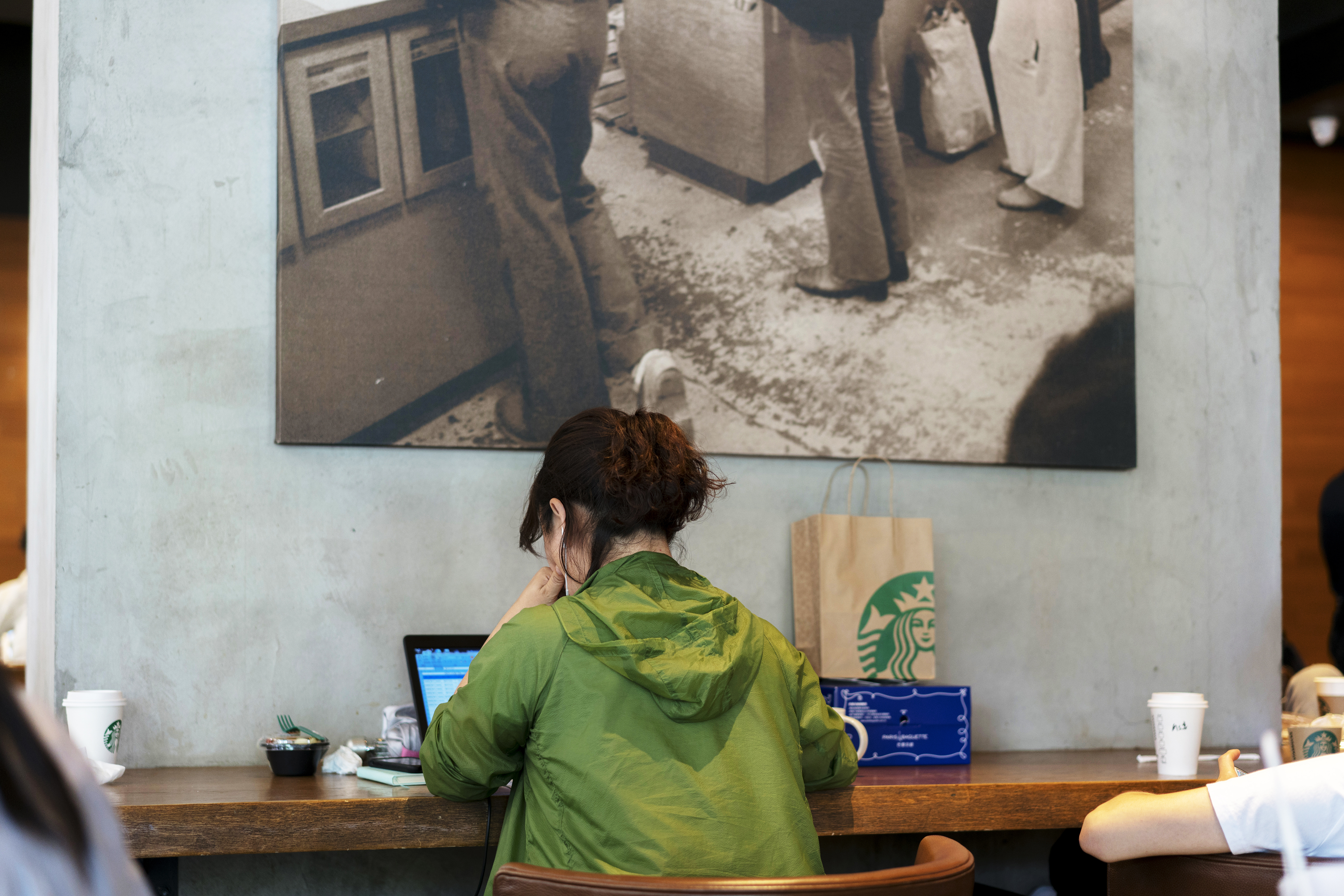 A girl is working on laptop in a Starbucks coffee shop. In