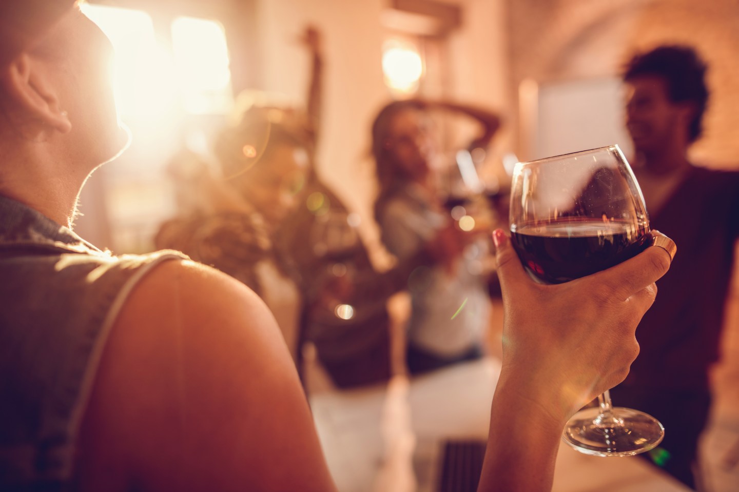 Close up of woman enjoying in wine at office party.