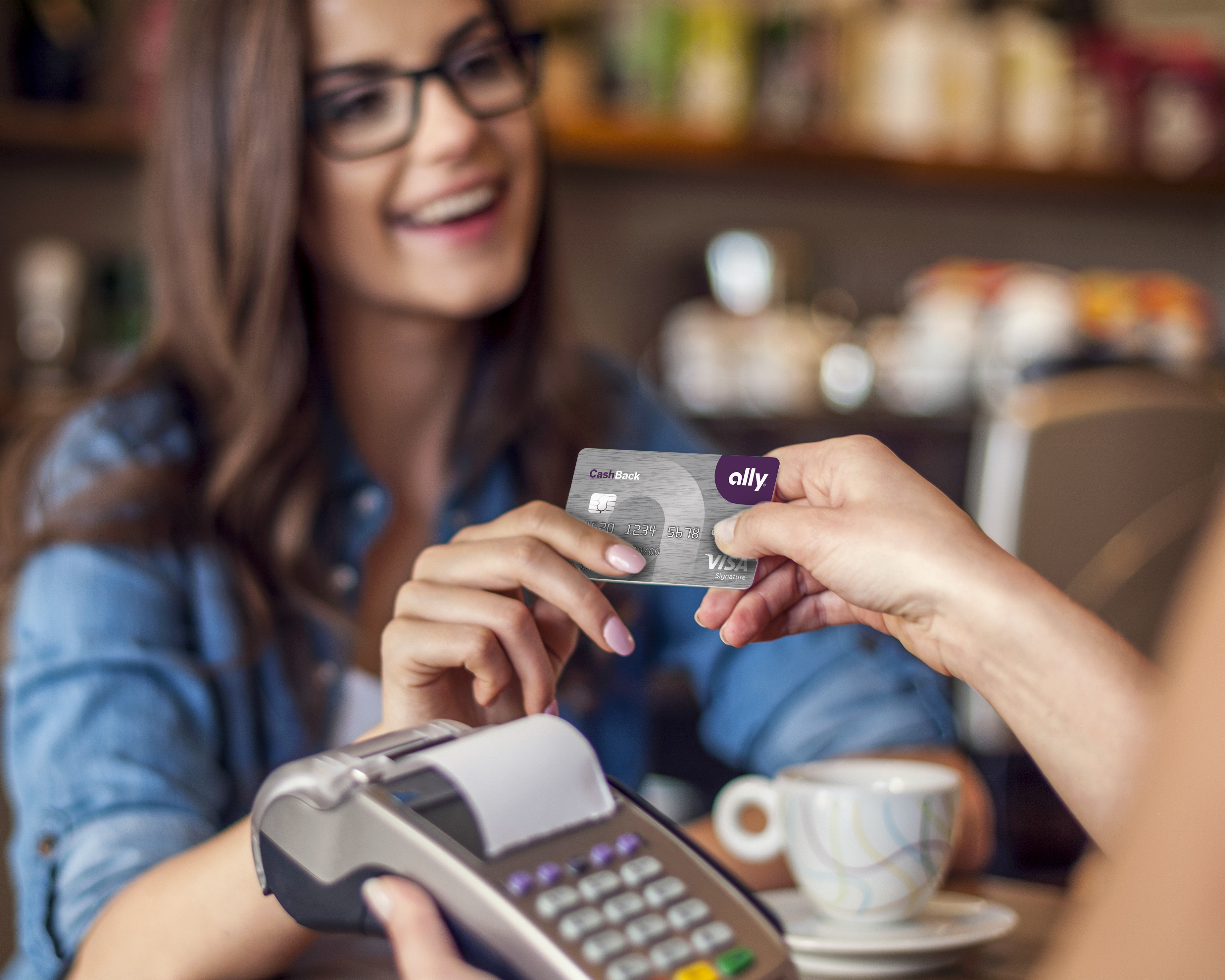 Happy woman paying for cafe by credit card