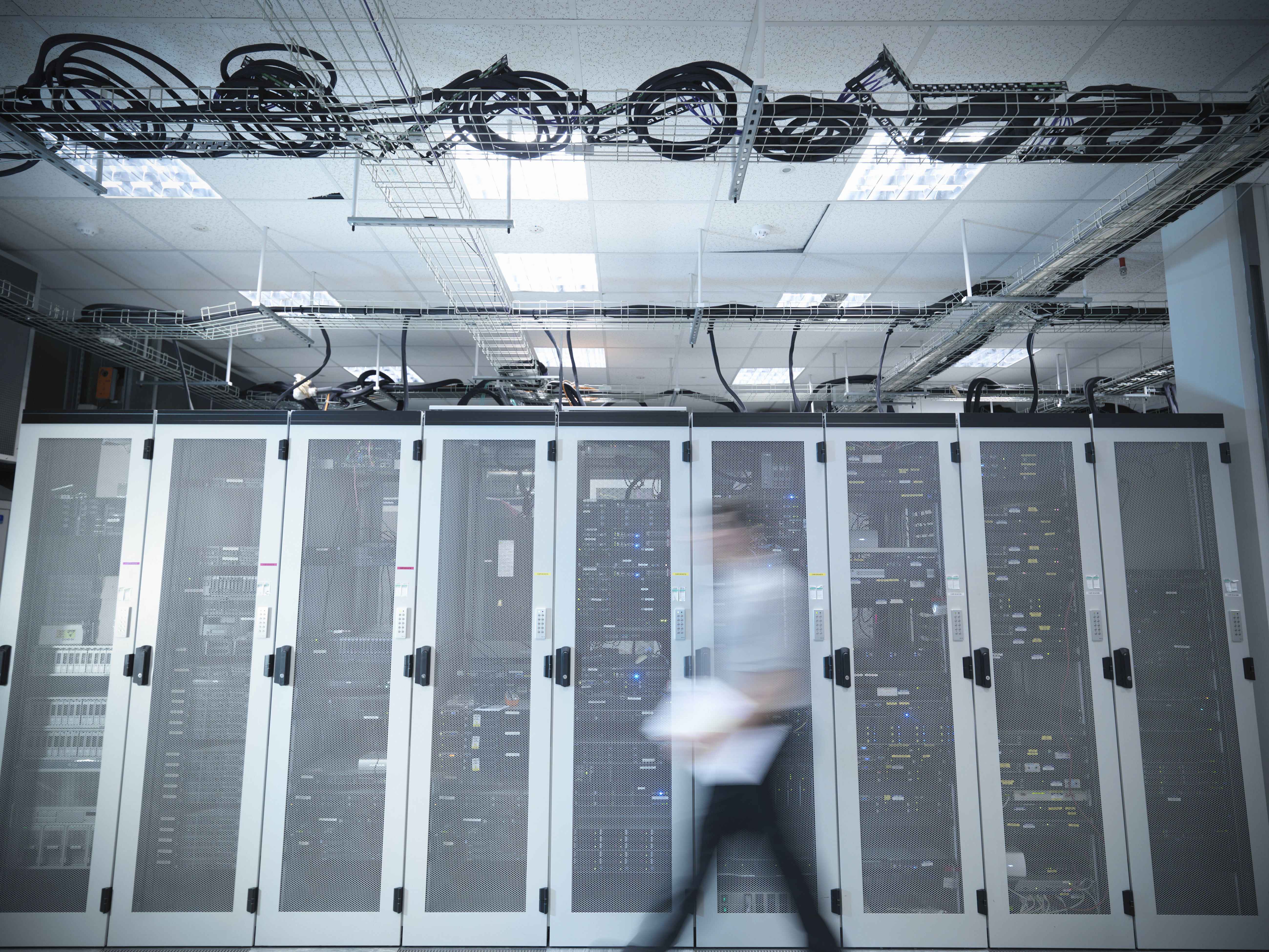 Man walking through computer server room, blurred motion