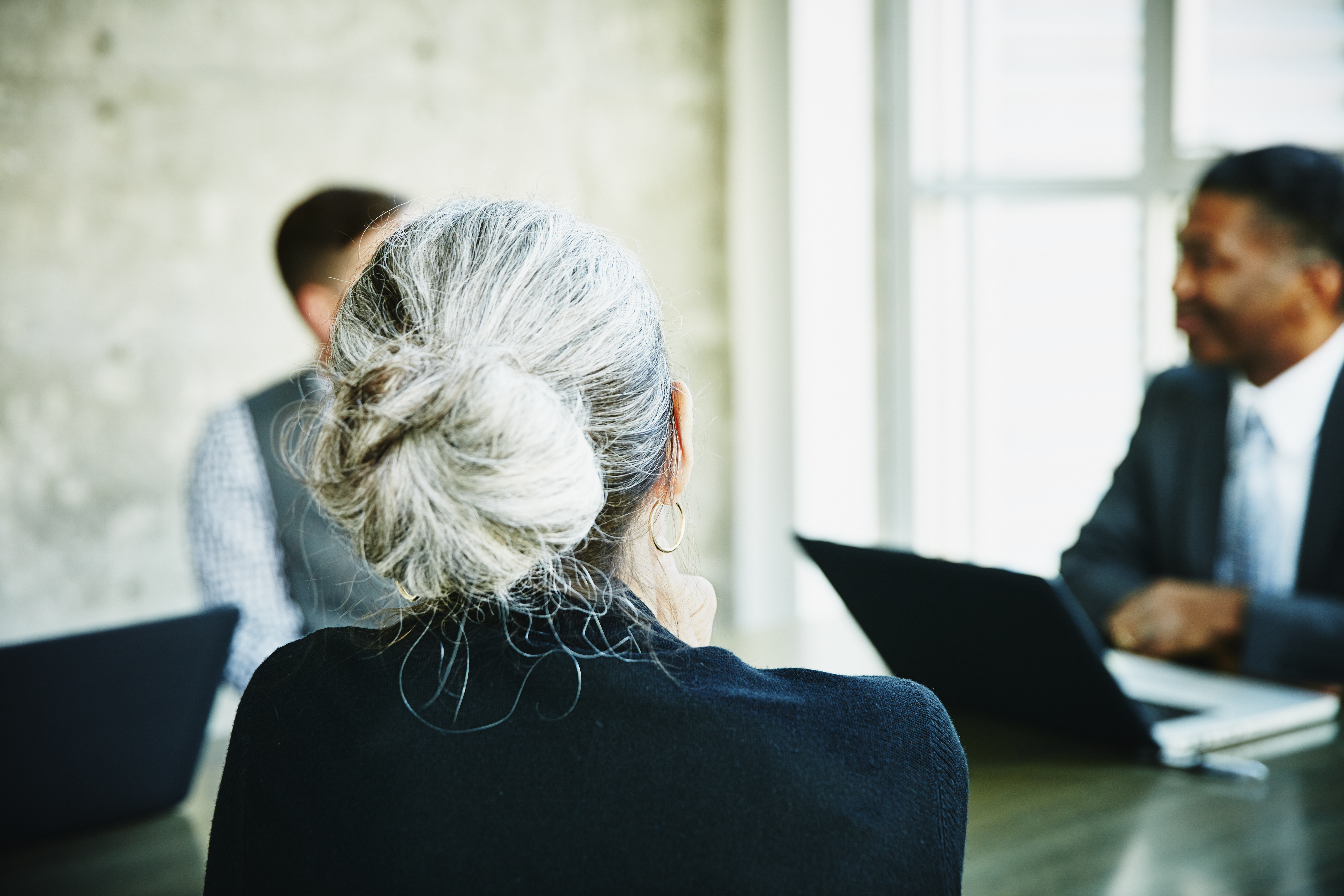 Mature businesswoman listening during meeting