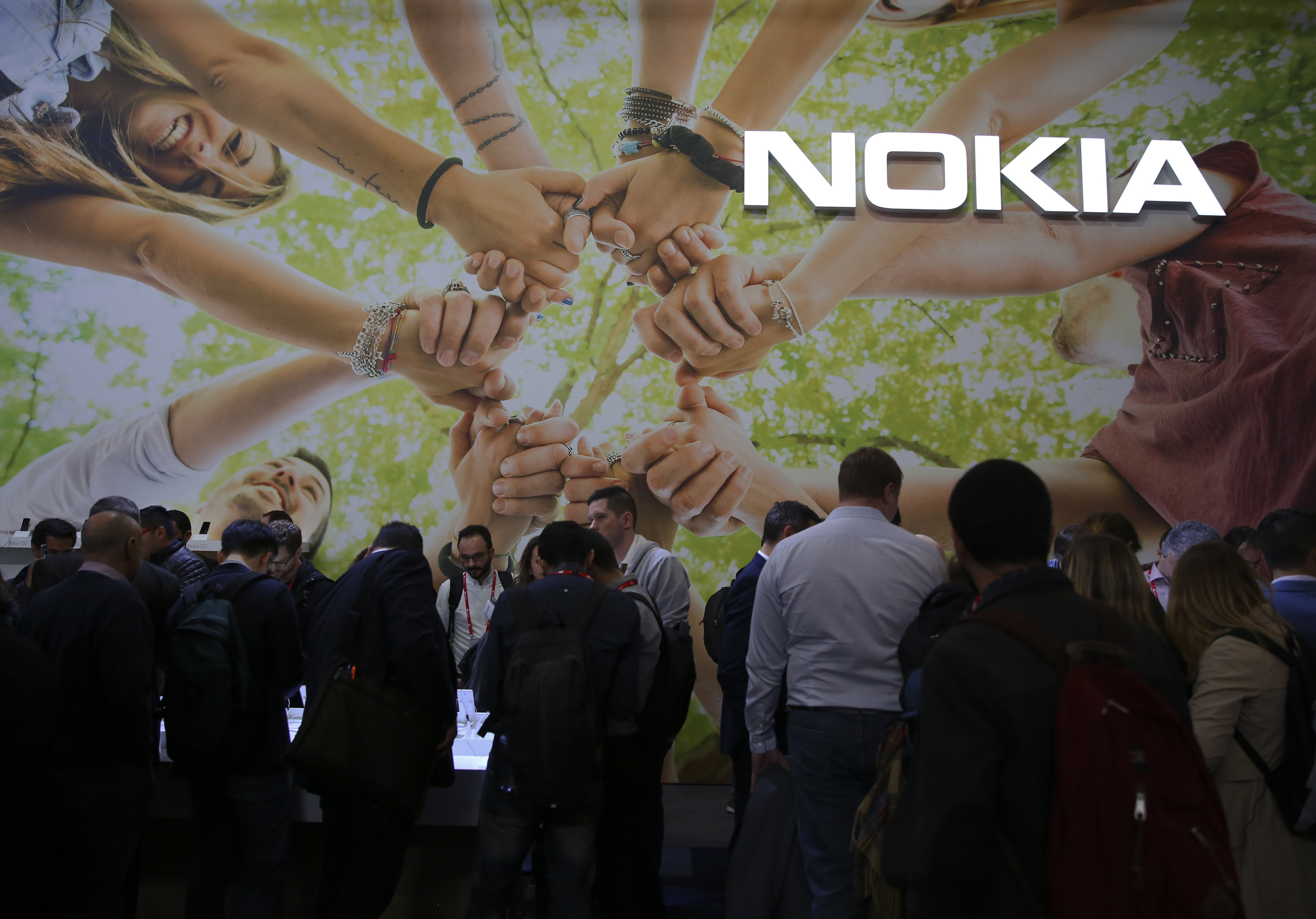 People check devices inside Nokia booth at Mobile World Congress in Barcelona